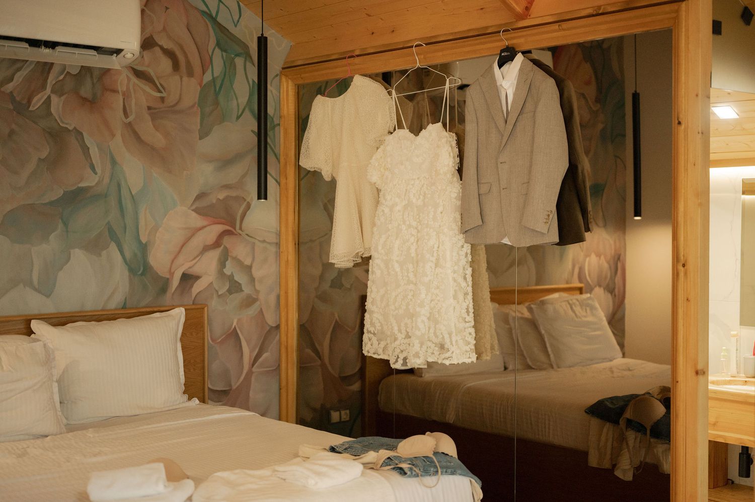 Vintage clothing hangs neatly on wooden hangers in an antique wardrobe display.