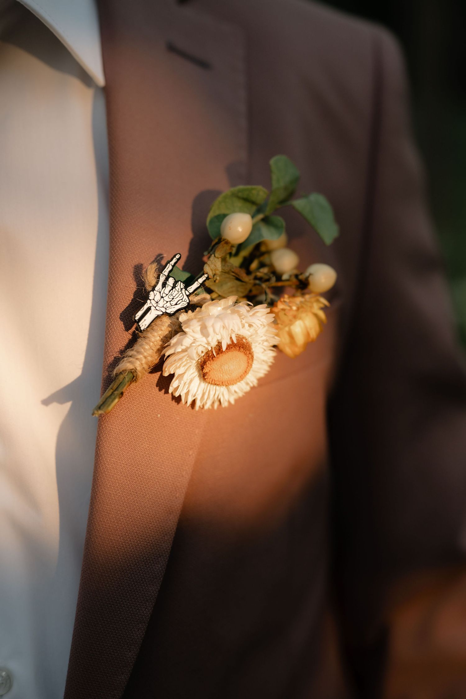 A sequence of white flowers and greenery casting shadows on a beige wall in varying levels of focus and blur.