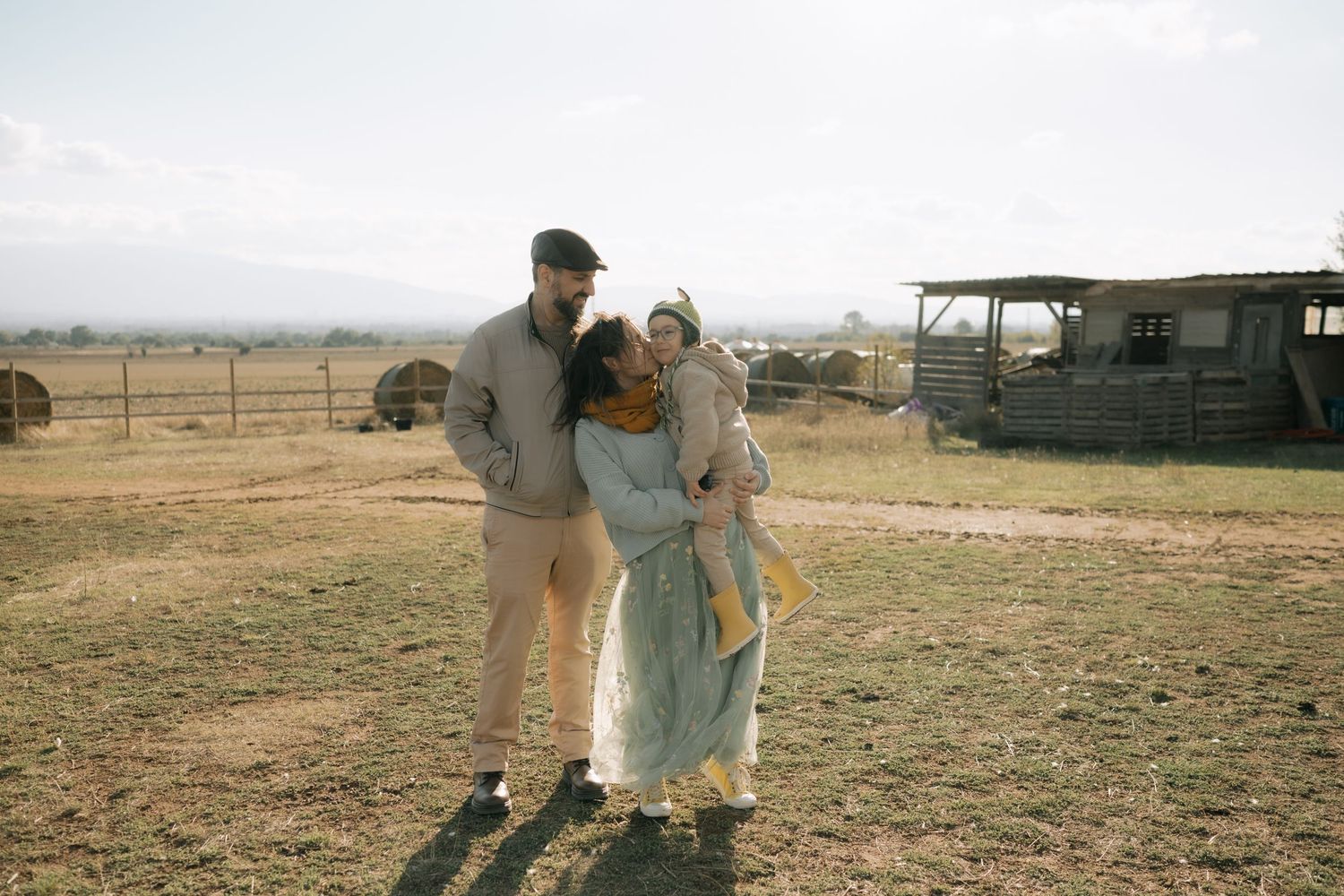 A series of six photos showing people walking and interacting on a dusty farm field with buildings in the background.