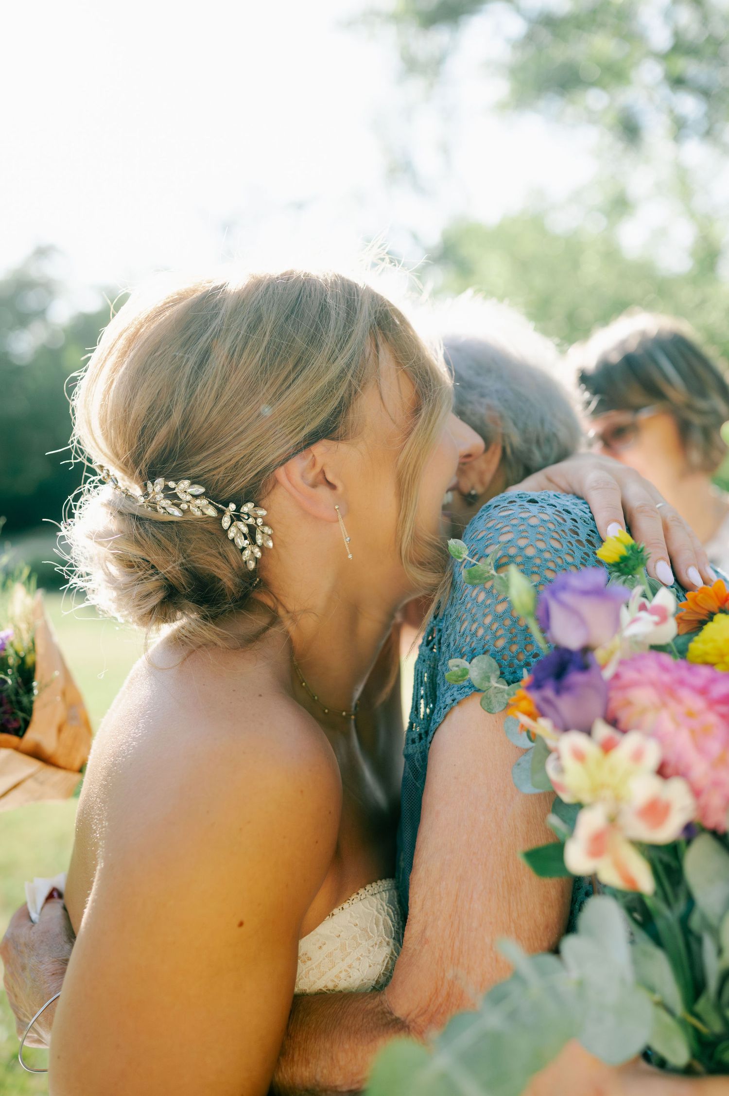 A tender moment shared between a couple with colorful flowers during an outdoor wedding celebration.