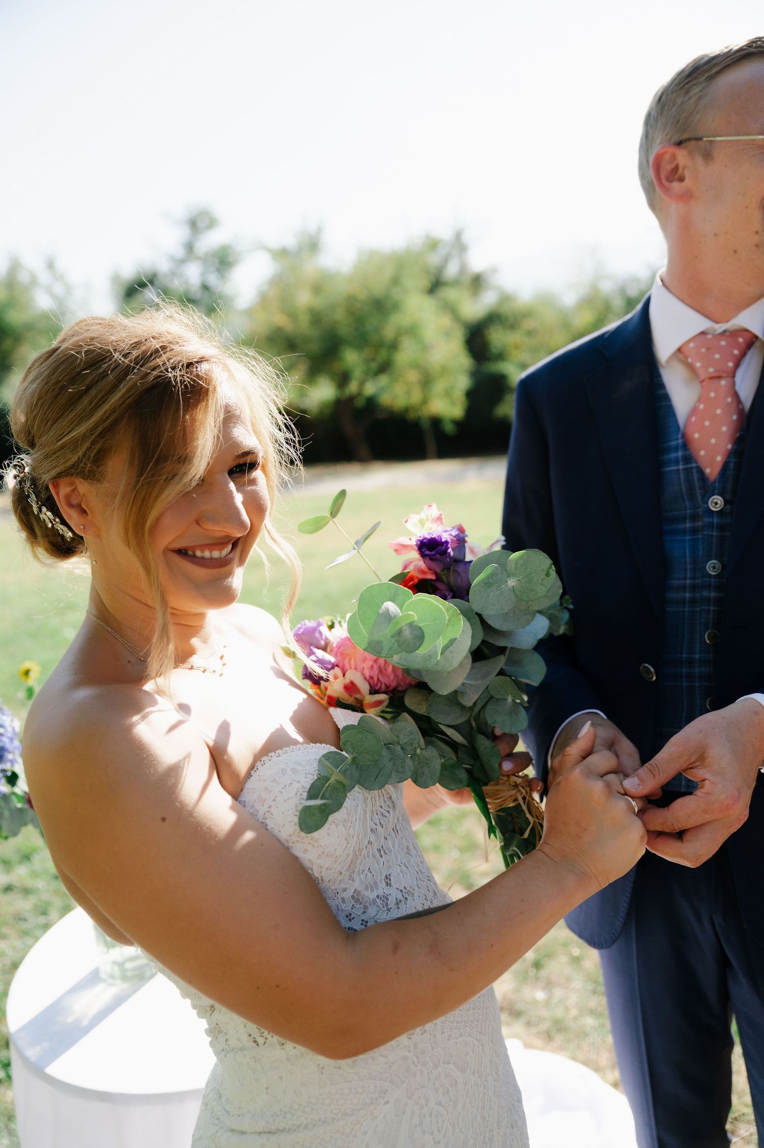 Joyful moments captured with colorful bouquets during an outdoor wedding celebration.