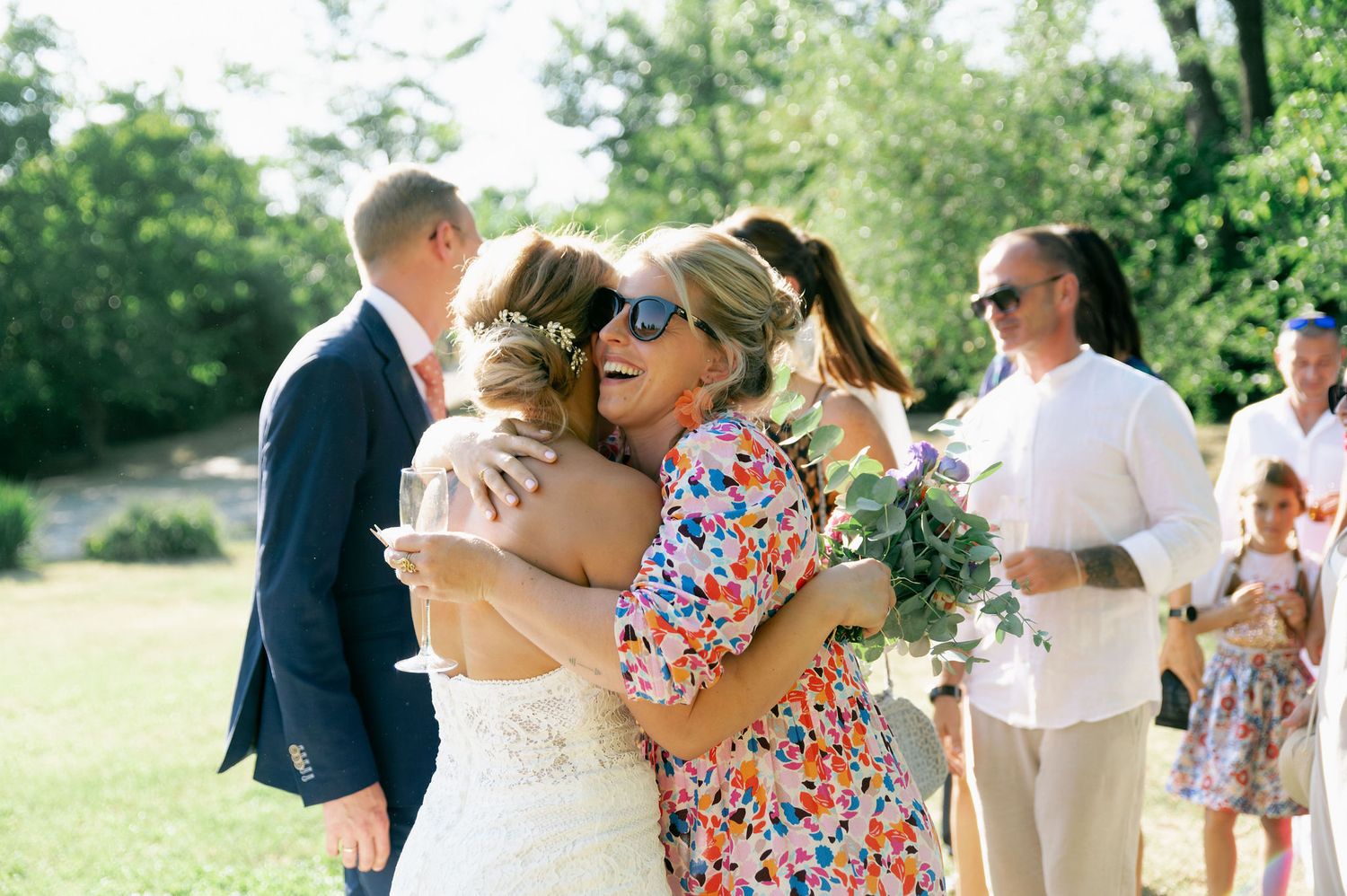 Candid moments from a summer wedding celebration with guests in colorful attire.