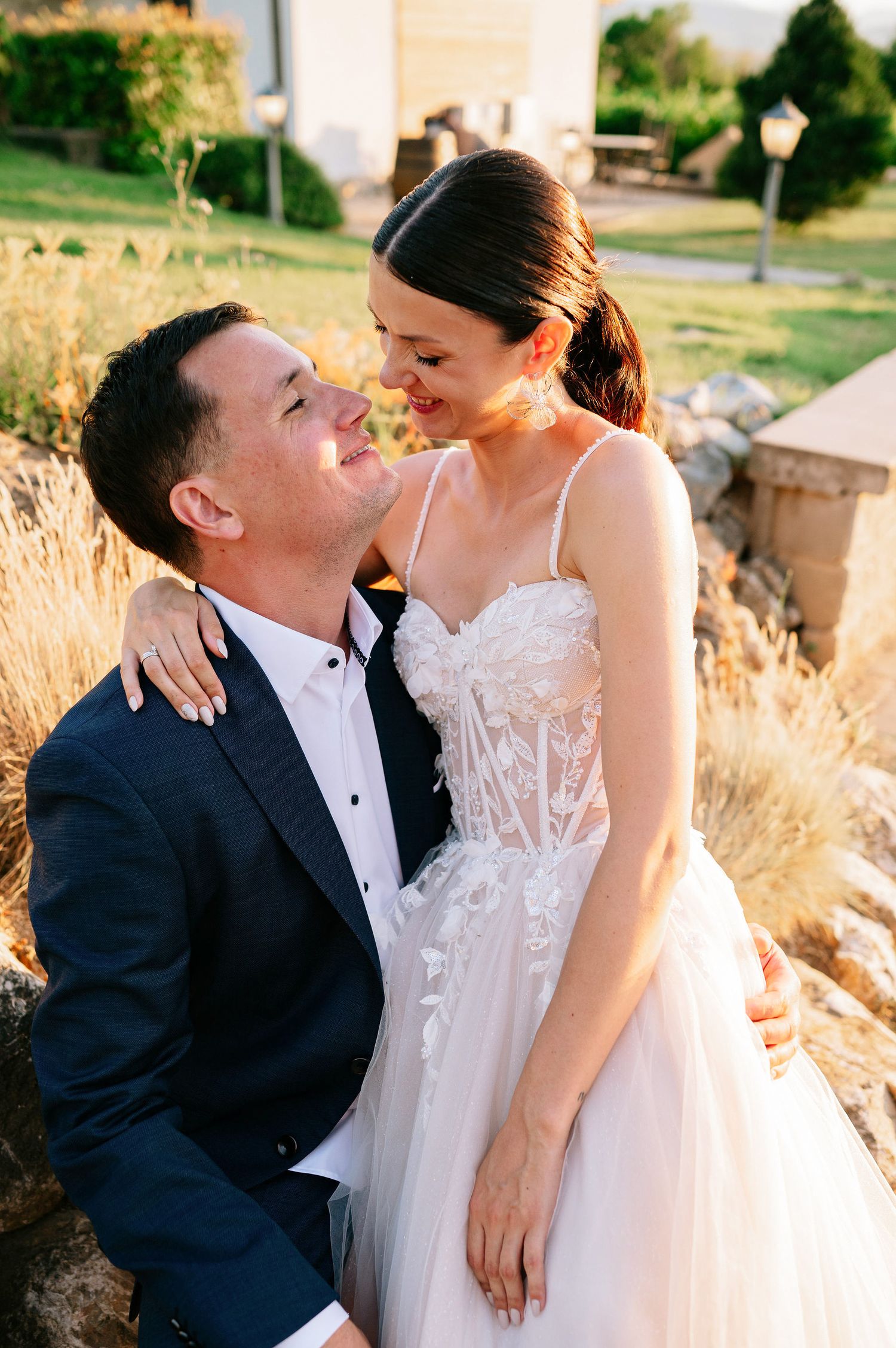 Romantic sunset portrait of couple in wedding attire sharing intimate moments.