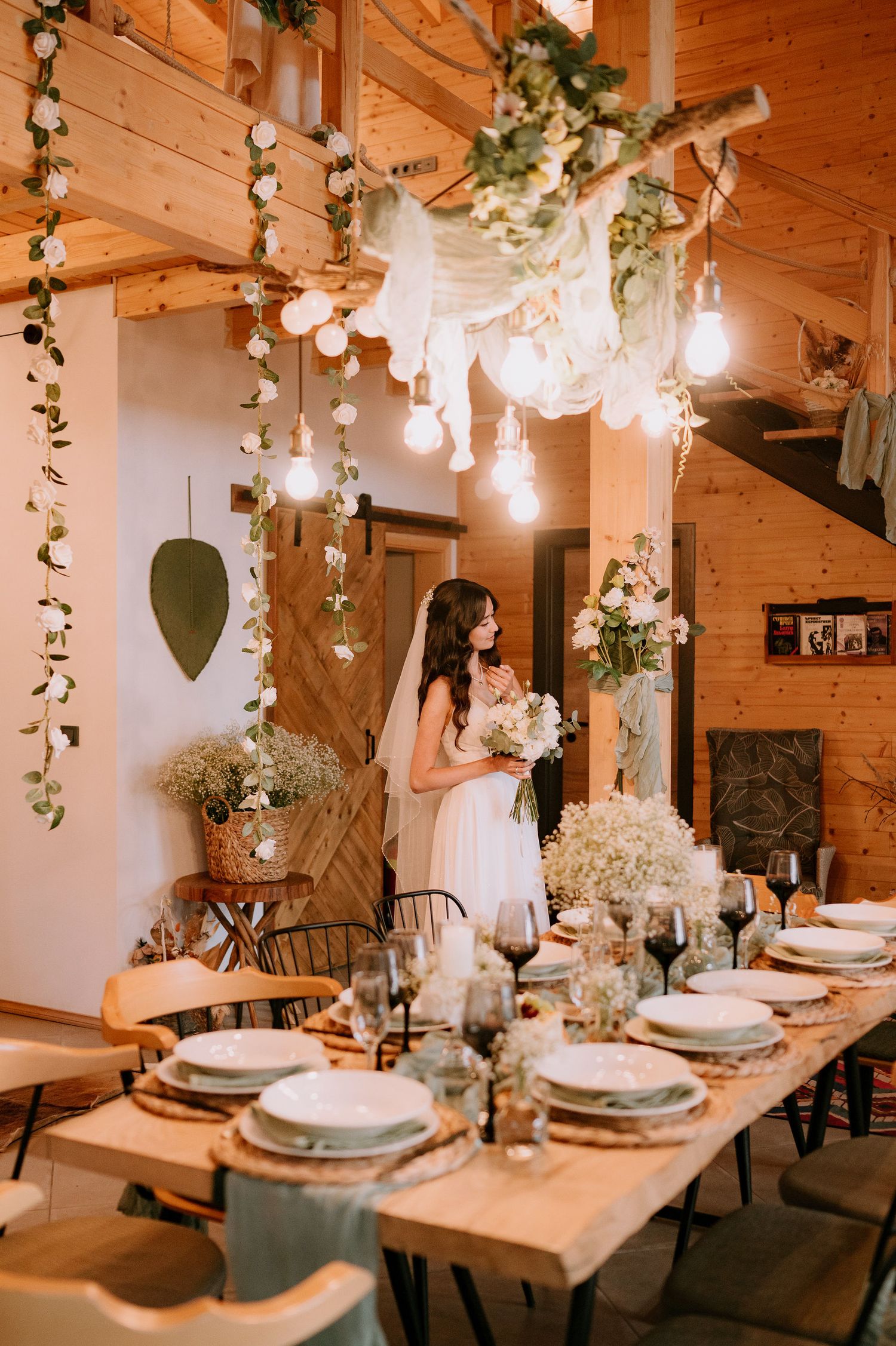 Rustic dining room with wooden beams and hanging lights decorated for an elegant wedding reception.