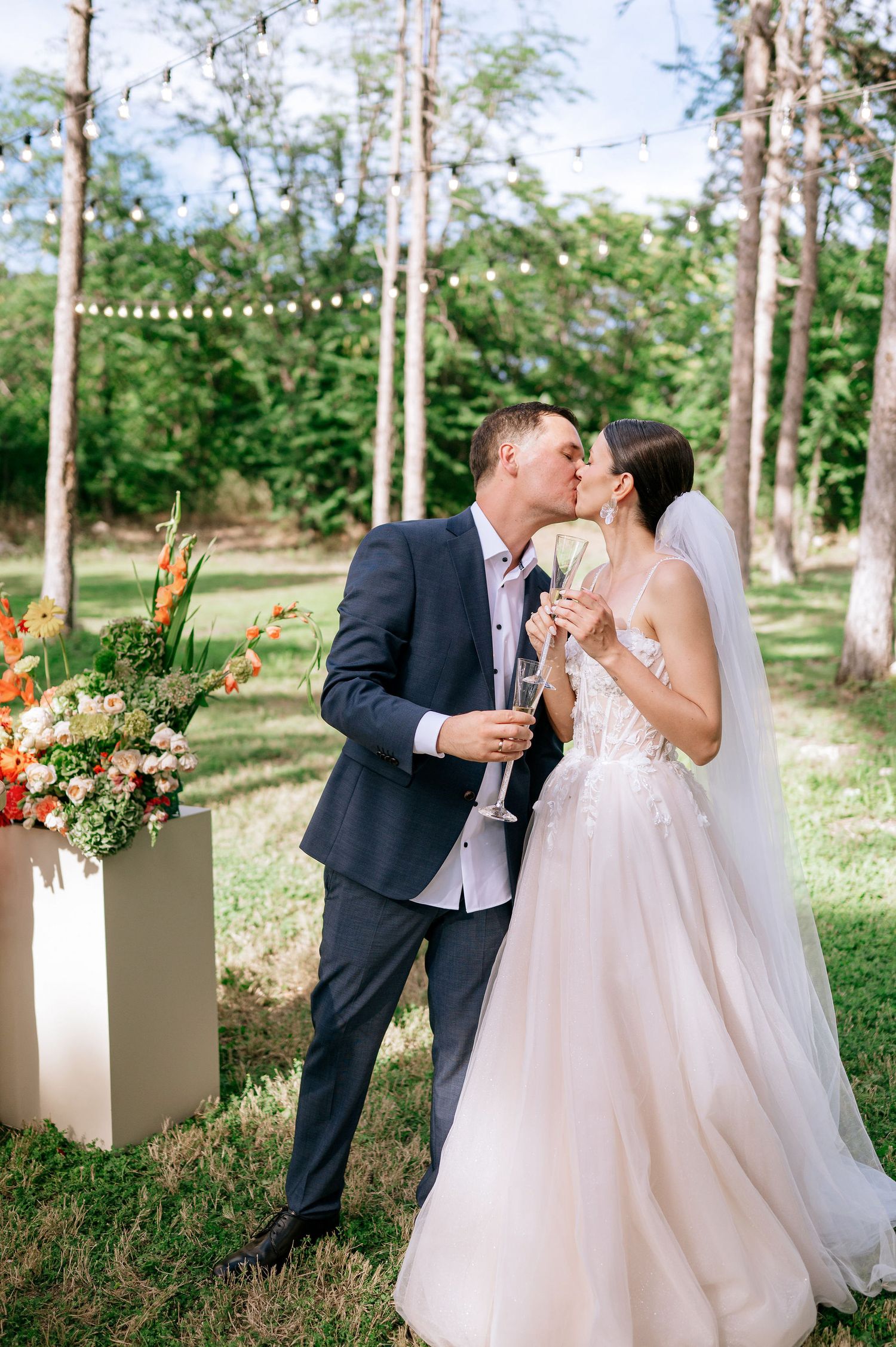 Newlyweds laugh together during their outdoor forest wedding celebration.