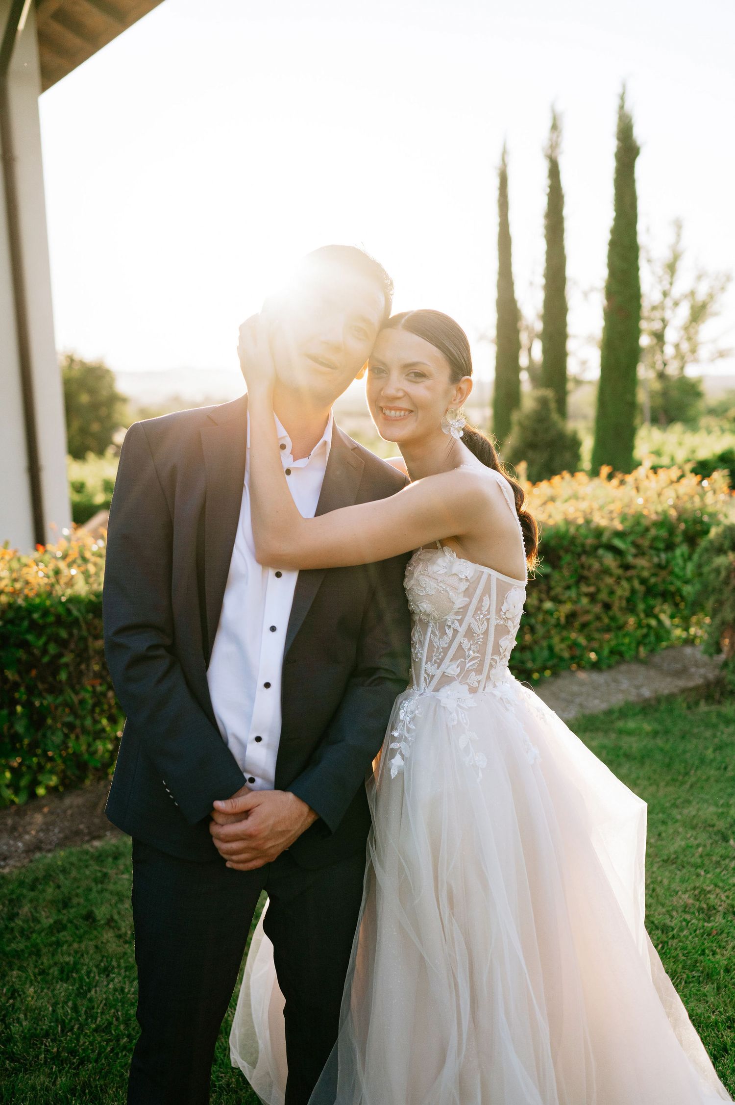 Intimate wedding dance captured during golden hour with cypress trees in background.