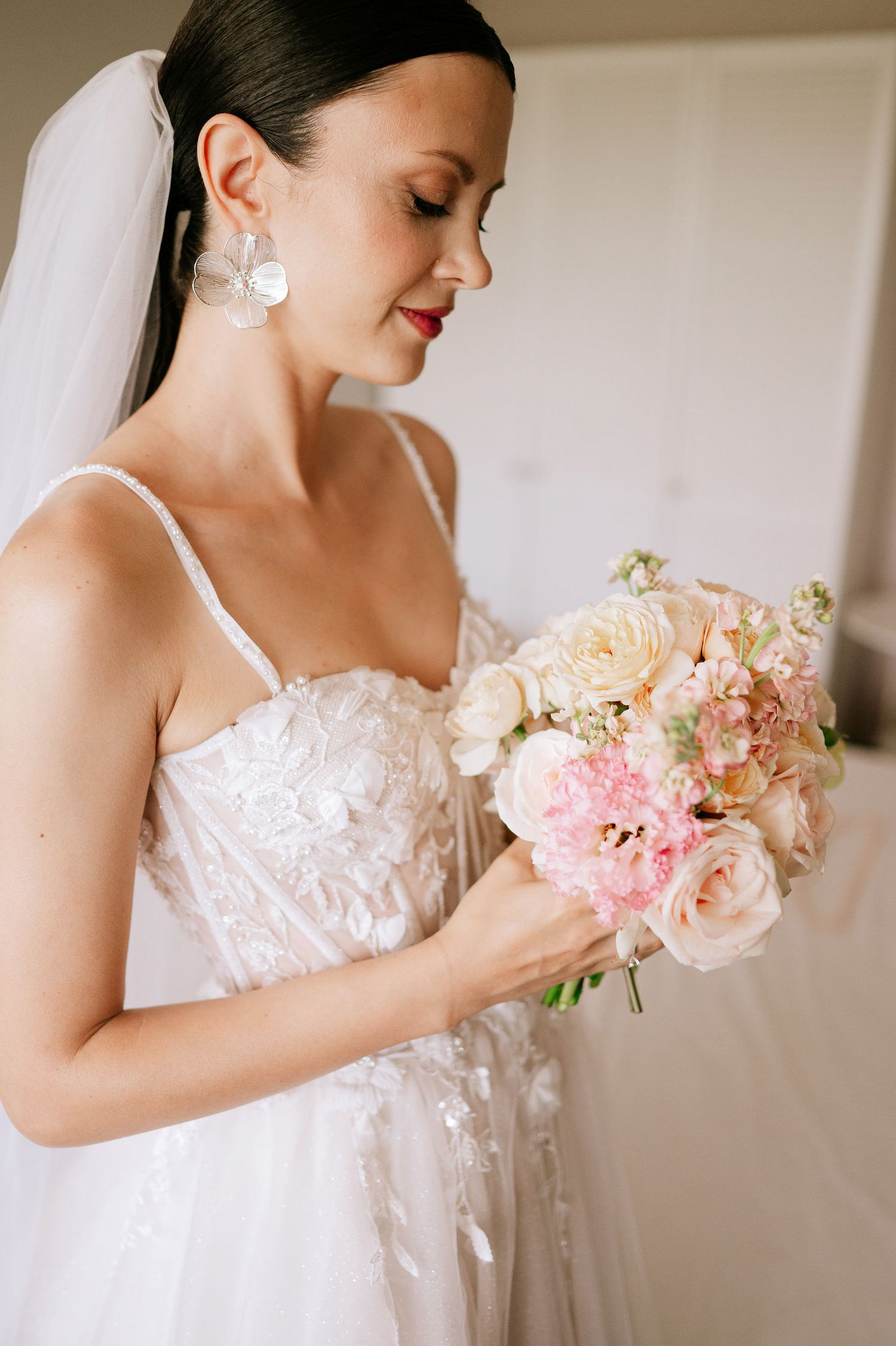 Elegant bridal portrait with a pastel bouquet and detailed lace wedding dress.
