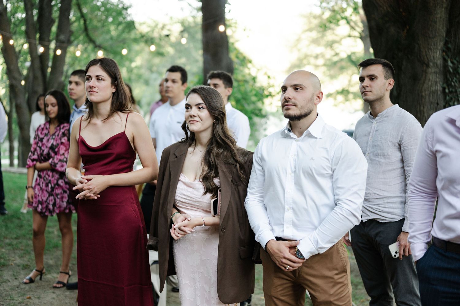 Wedding guests gathered in a forest clearing during an intimate outdoor ceremony.