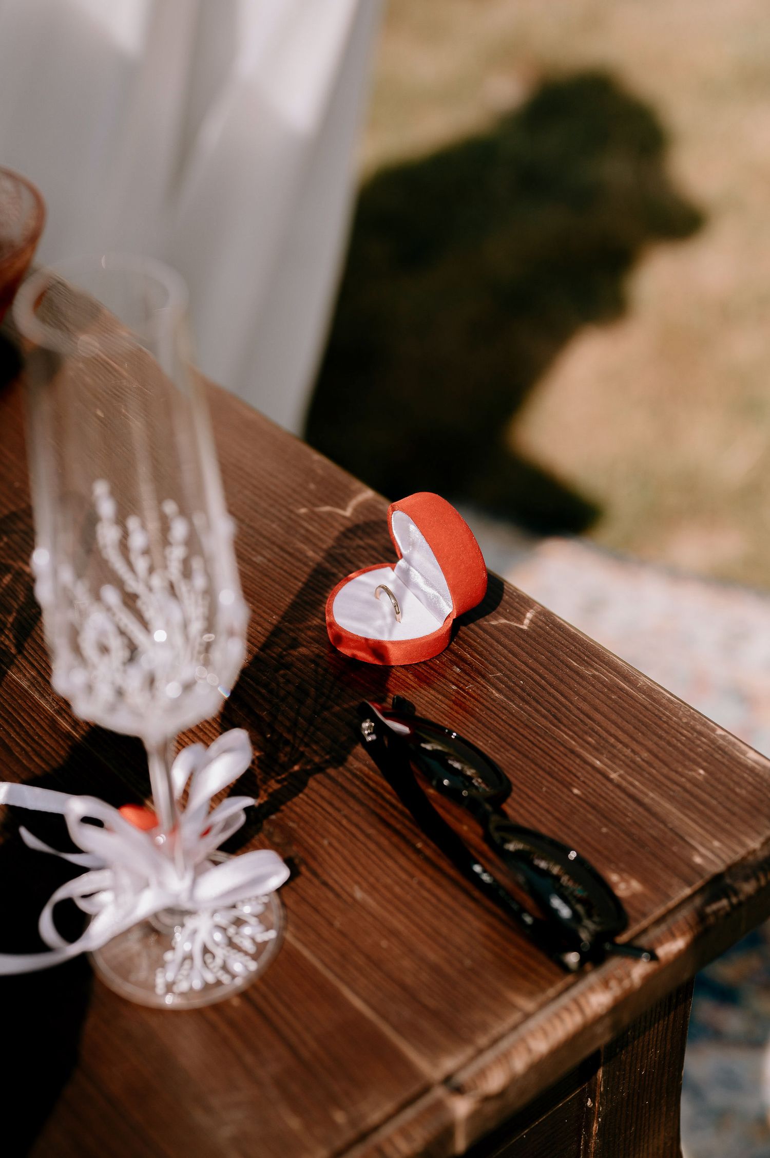 Wedding rings and decorative elements arranged on a dark wooden surface.
