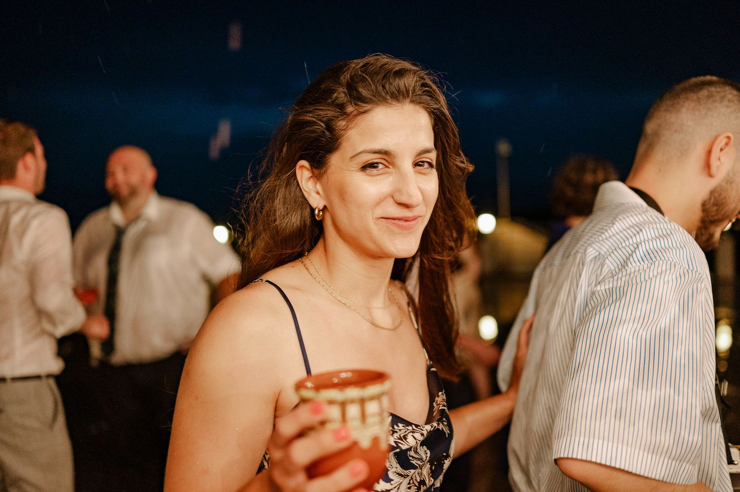 Wedding guests socialize and celebrate during an evening reception.