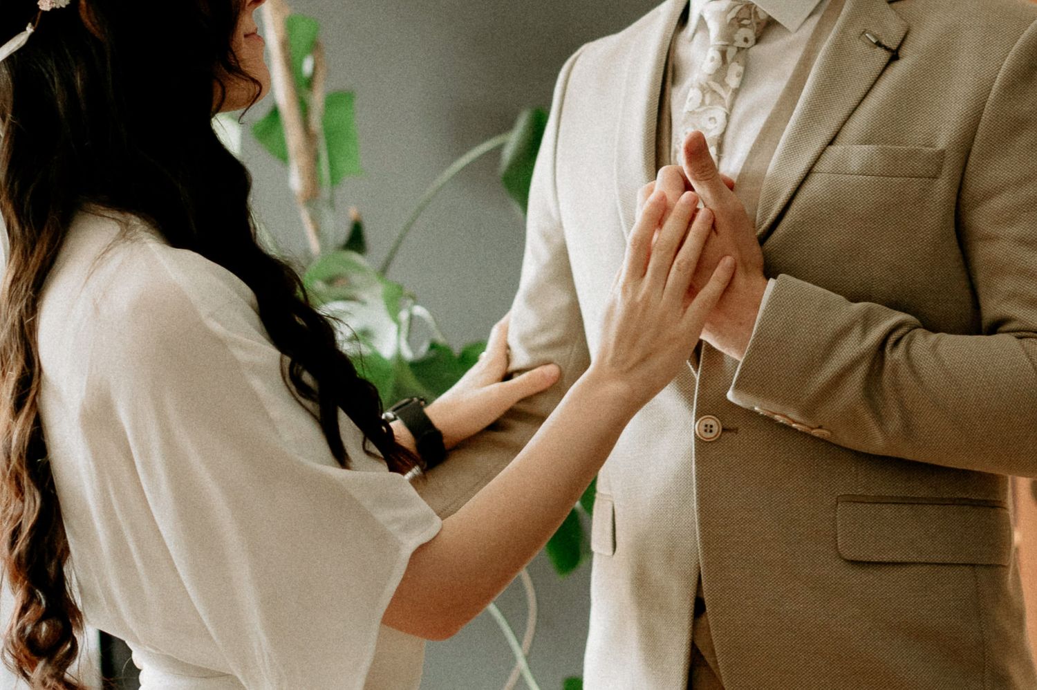 An intimate moment between a couple wearing white and beige formal attire.