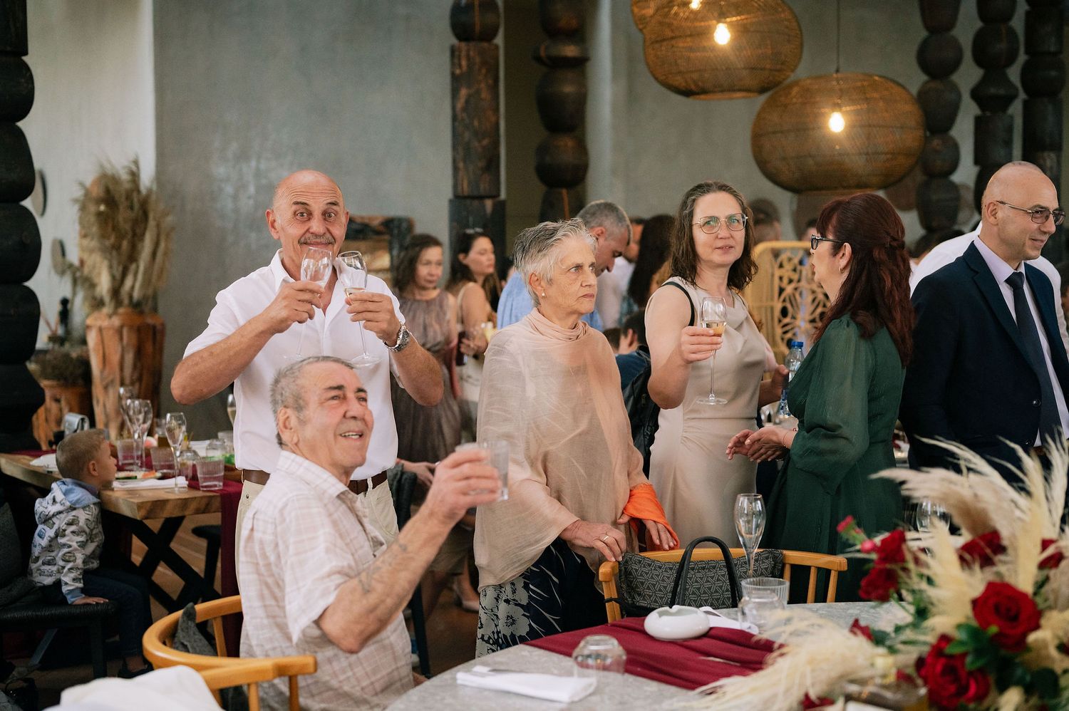 Guests raise their glasses in a toast during an elegant indoor celebration.