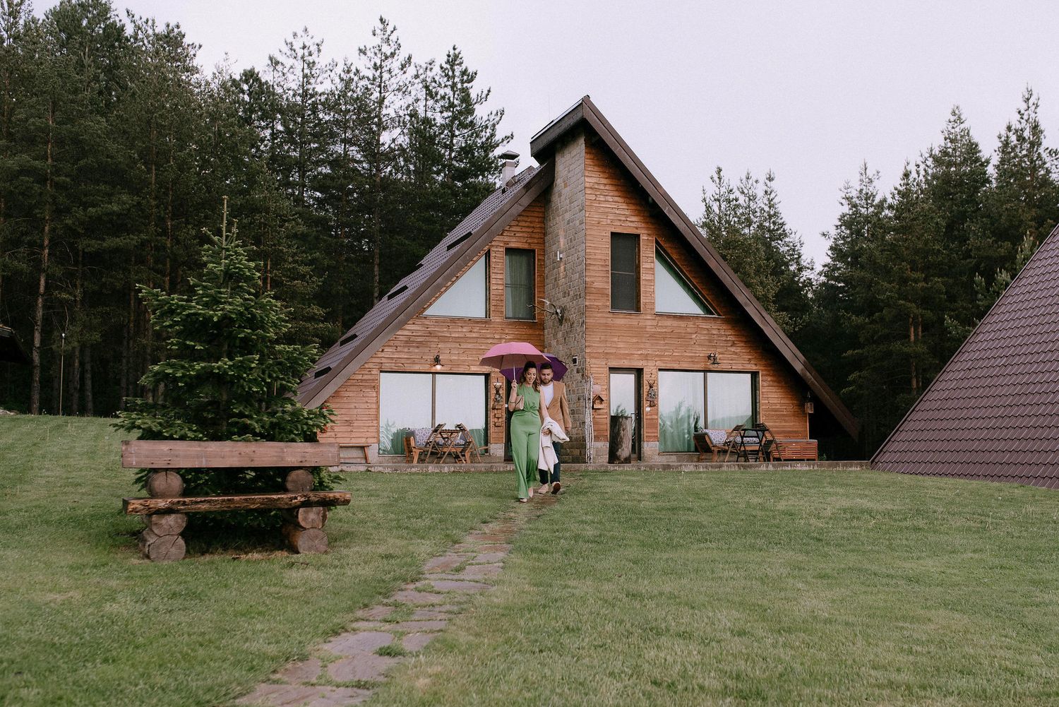 A-frame cabins nestled among pine trees at an outdoor mountain venue.