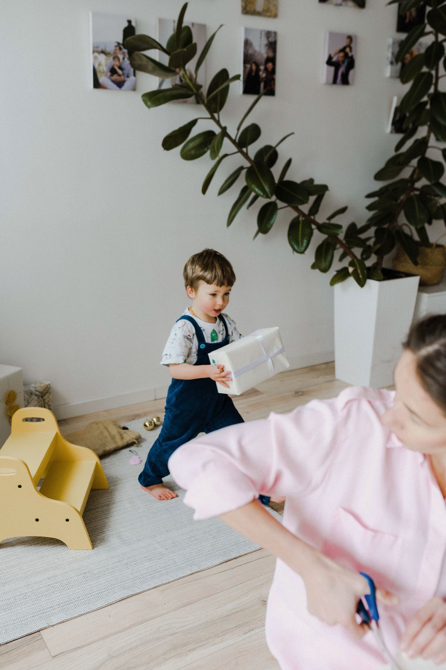 A sequence of images showing a toddler in blue overalls crawling across a light-colored floor near a yellow toy.