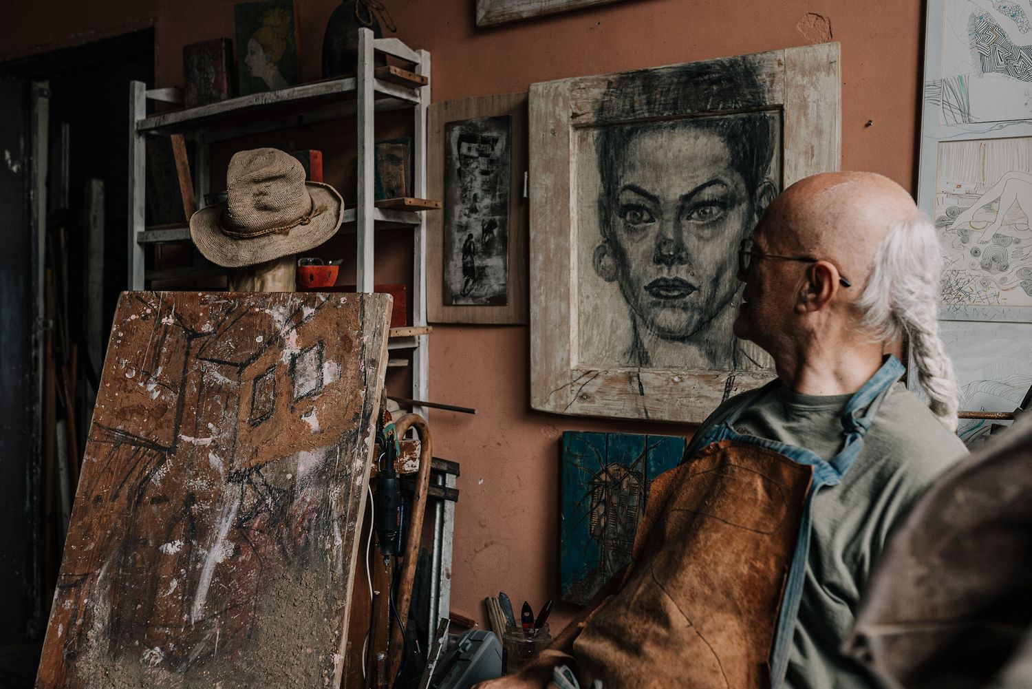 Art studio walls decorated with portrait sketches and artwork in a rustic setting.