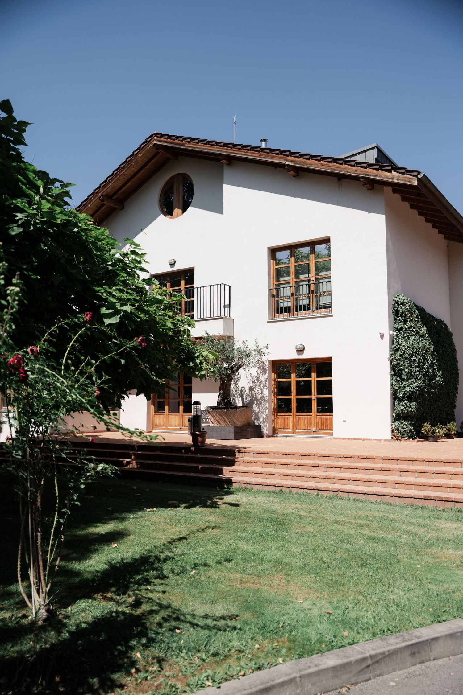 Modern white house with wooden deck and landscaped lawn features multiple exterior views showing architectural details.