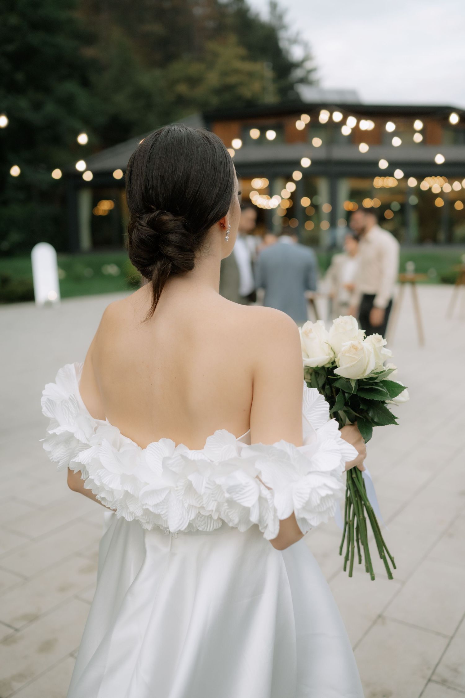 A series of photos showing the back of an elegant white off-shoulder wedding dress with ruffled details and a bouquet.