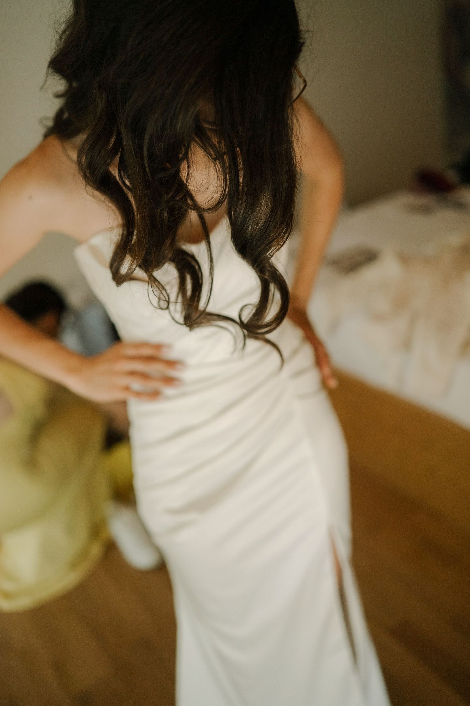 Person wearing a white dress spins and twirls in a graceful dance motion on a wooden floor.