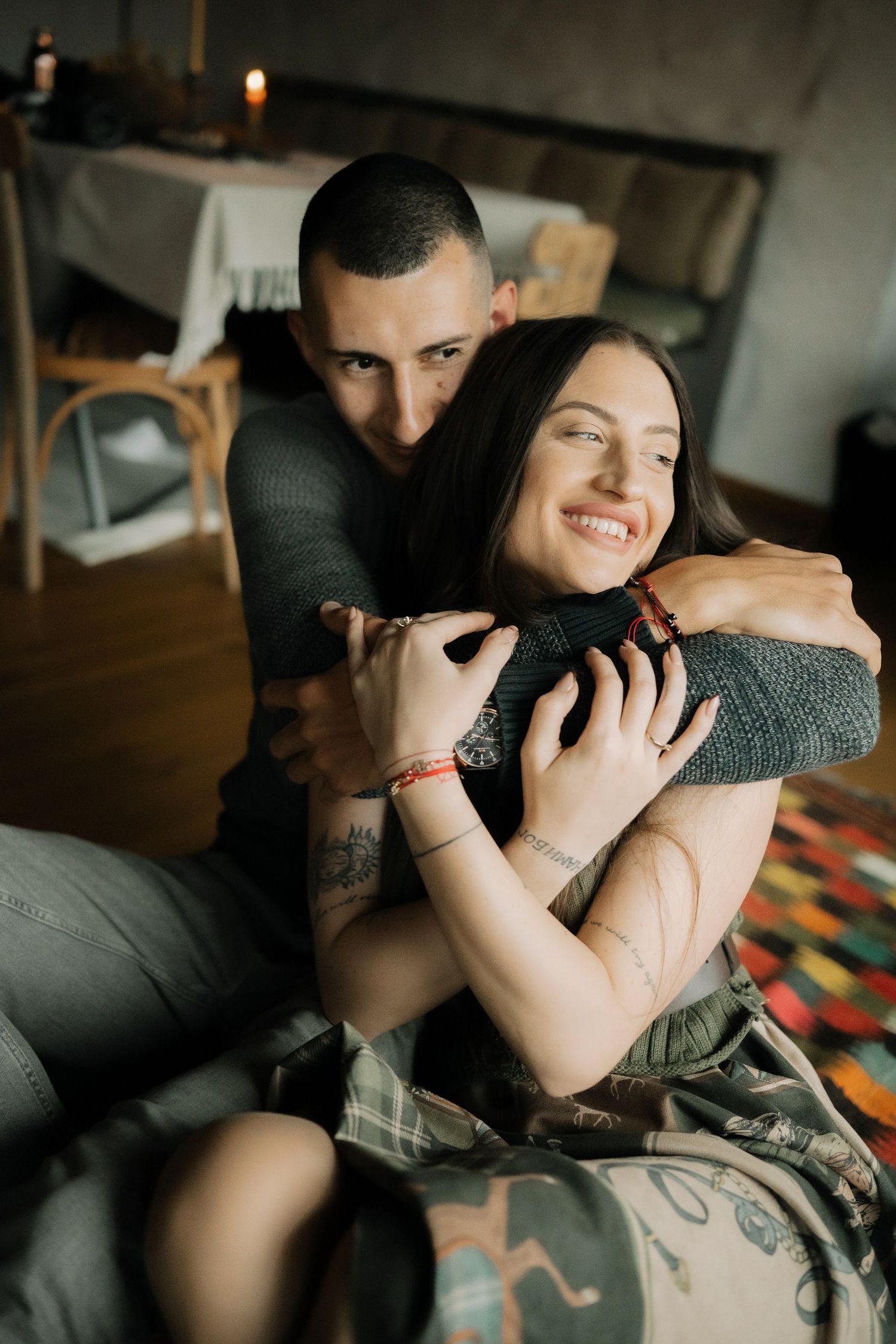 A cozy intimate moment captured indoors showing affection and embracing on a colorful patterned couch.