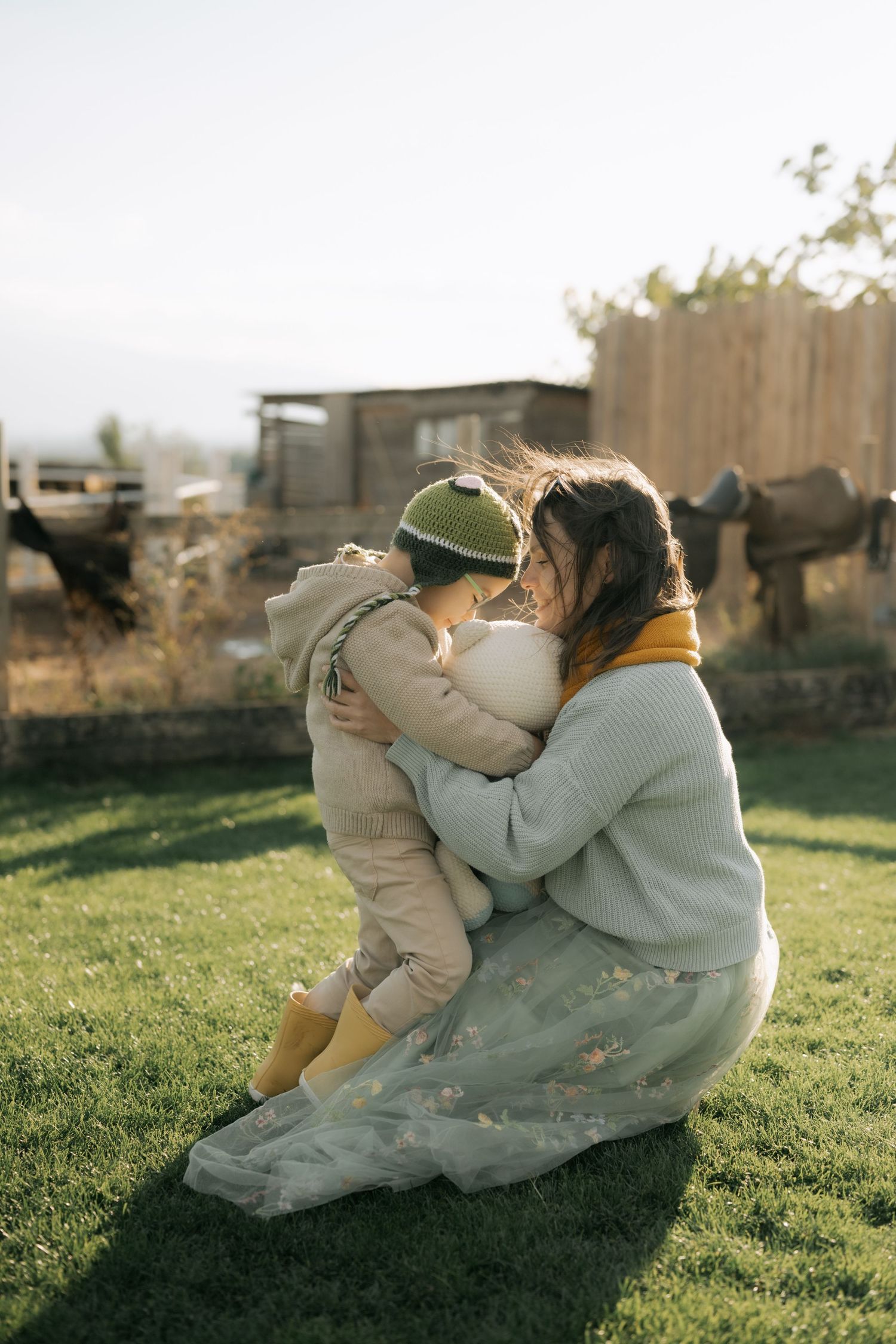 A series of intimate moments between a couple sitting on grass during golden hour.