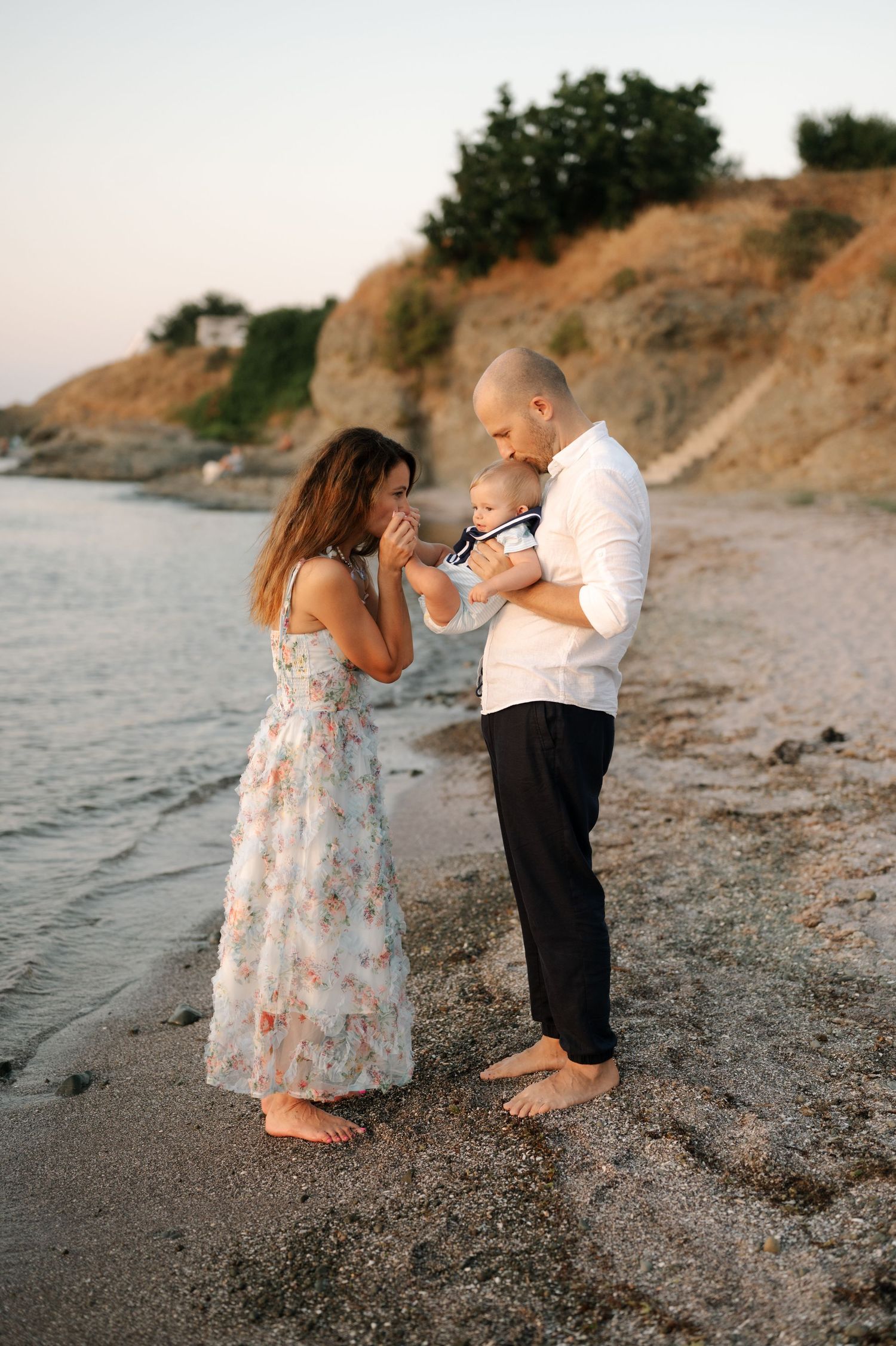 Two small children play together on a sandy beach at sunset creating a sweet moment by the water.