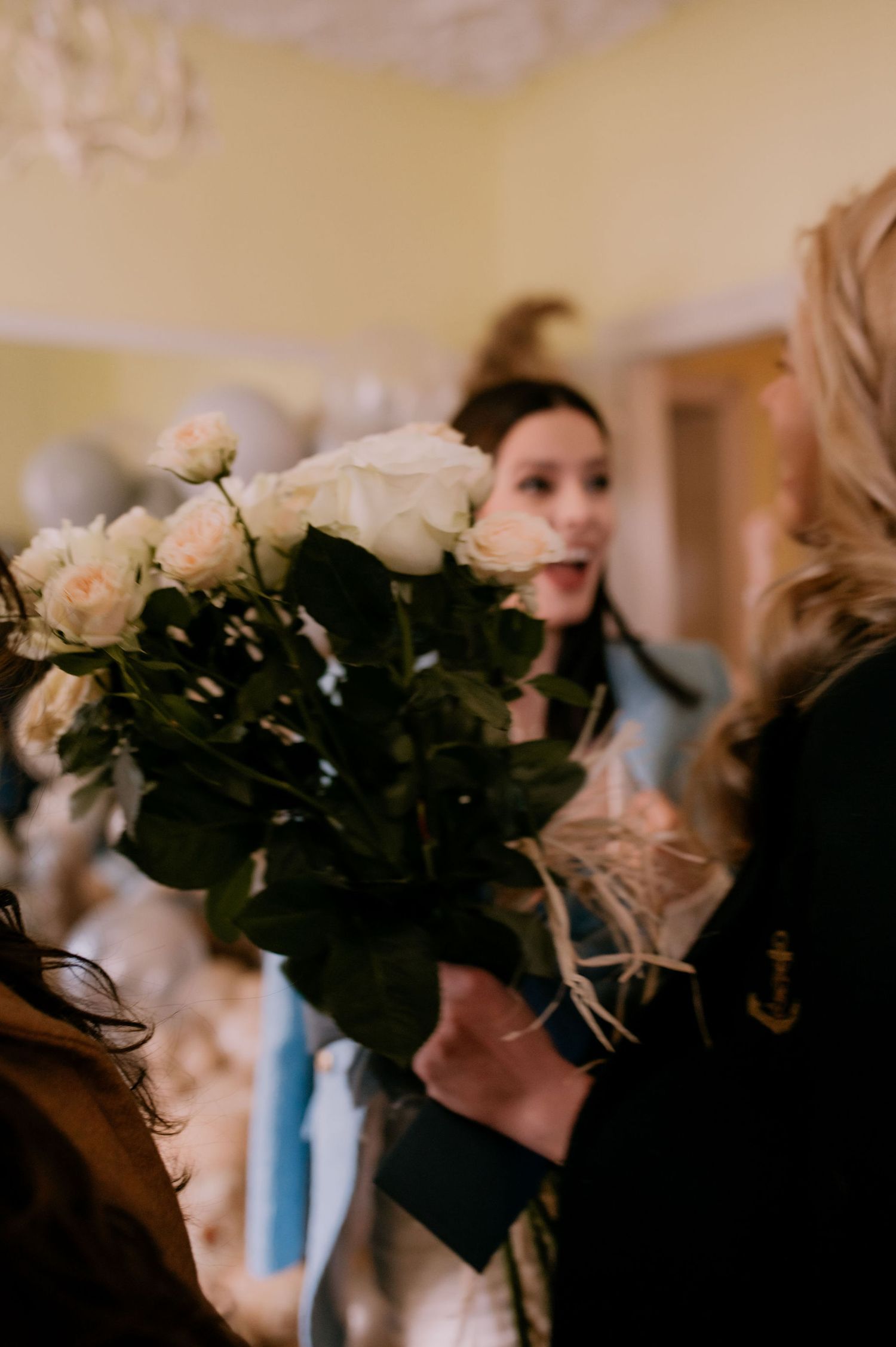 A row of white roses in bouquets creates an elegant floral display against a warm-toned background.