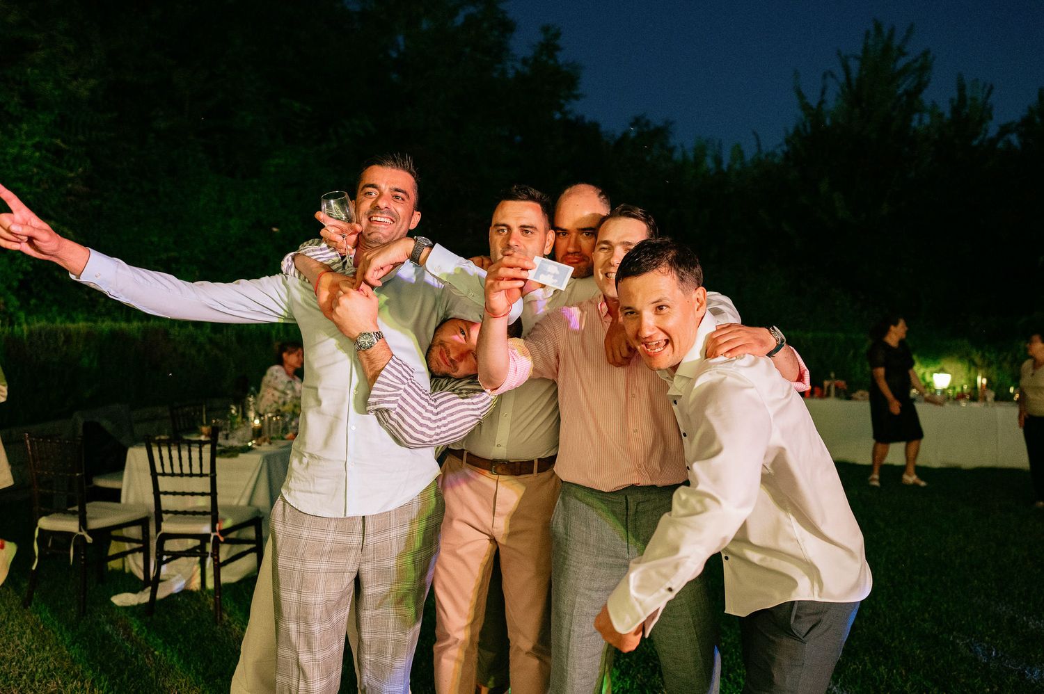 Wedding guests enjoying themselves on the dance floor during an outdoor evening celebration.