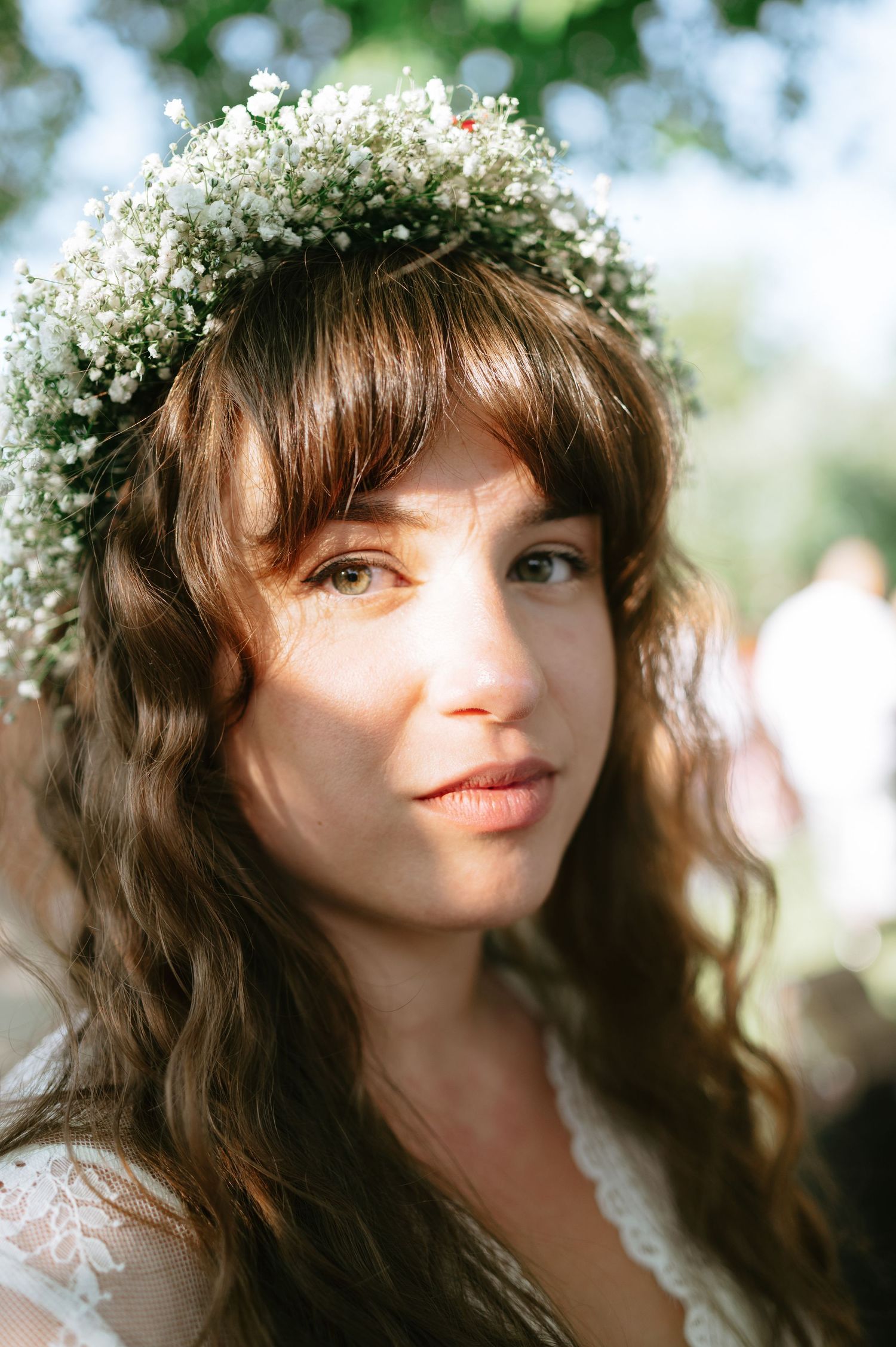 Close-up portrait of a bride wearing a delicate baby's breath flower crown.