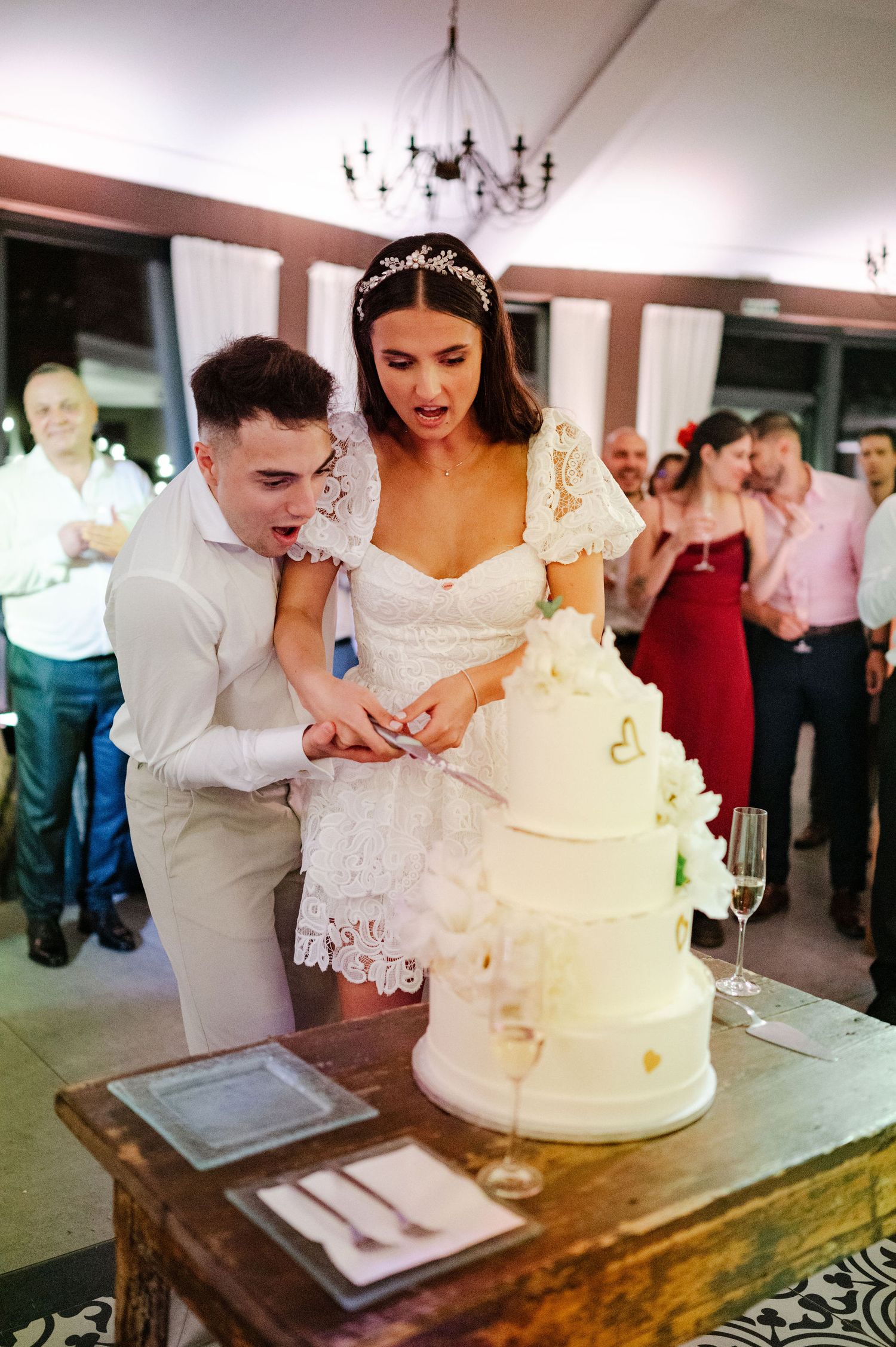 Wedding cake cutting moment captured during evening reception celebration.