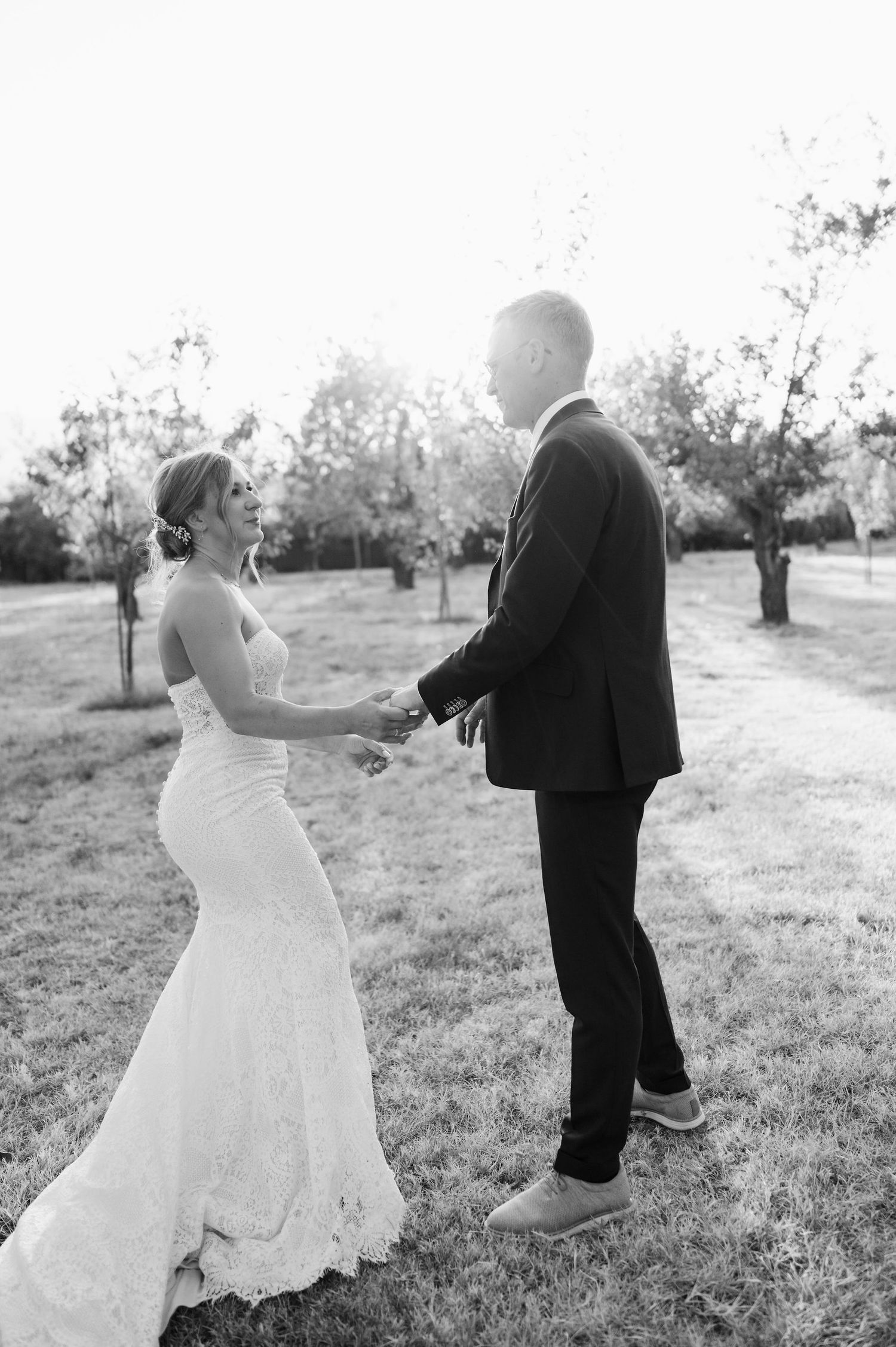 Black and white wedding portraits in rustic outdoor setting.