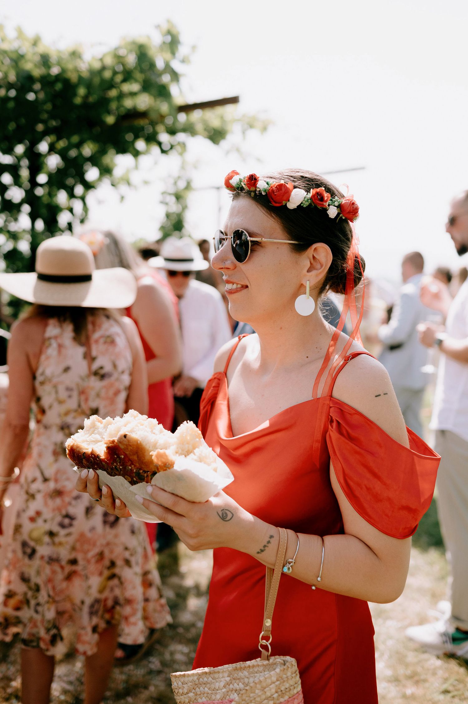 Wedding guests in bright summer attire enjoying an outdoor celebration.