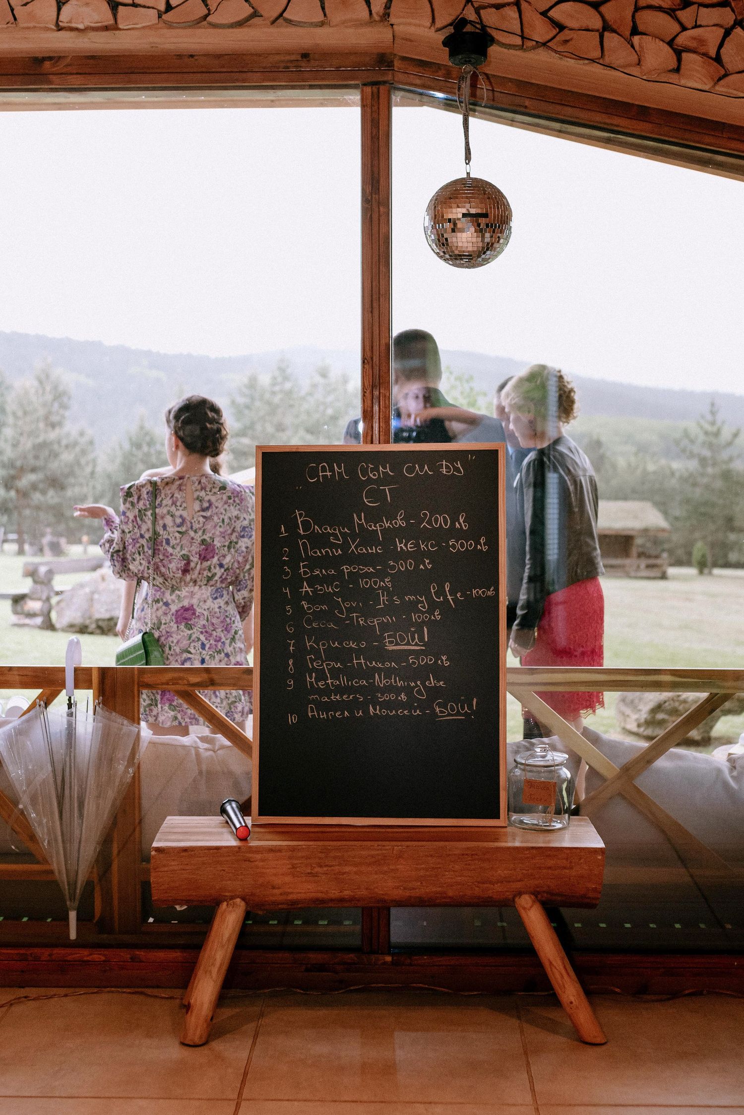 Rustic bar setup with chalkboard menu and wooden details at wedding reception.