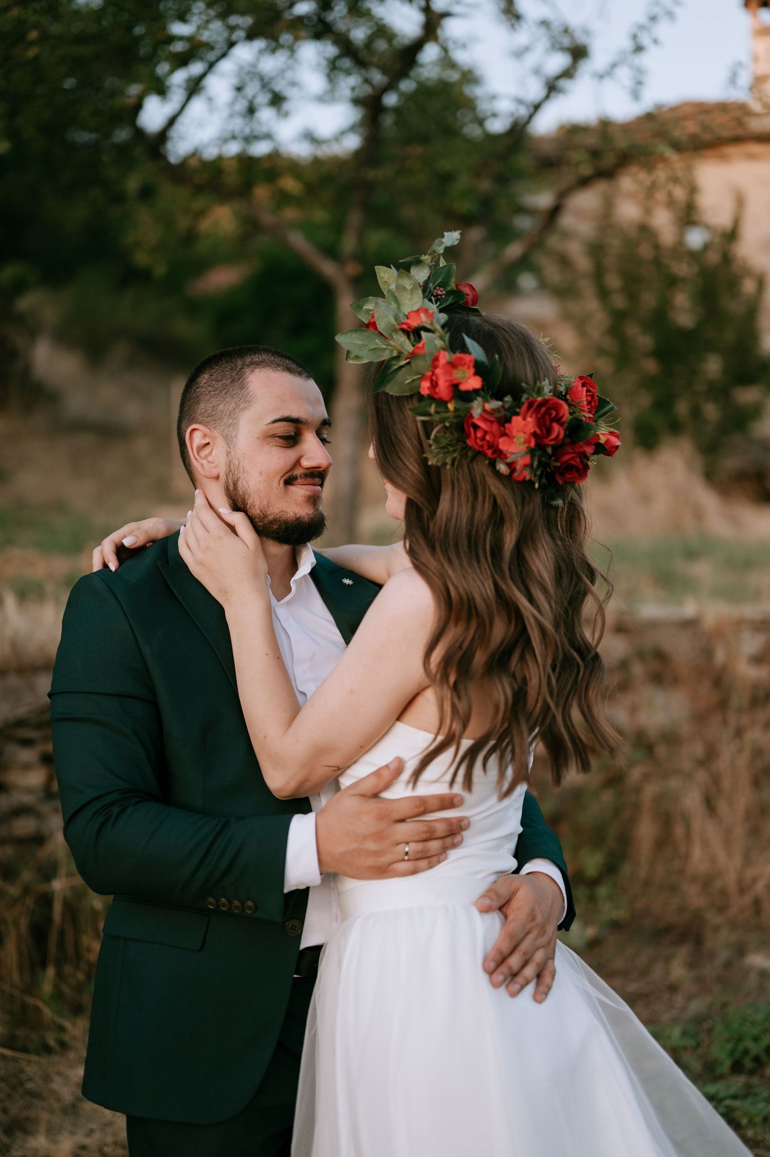 Intimate wedding portraits capture loving embraces between newlyweds in an outdoor rustic setting.