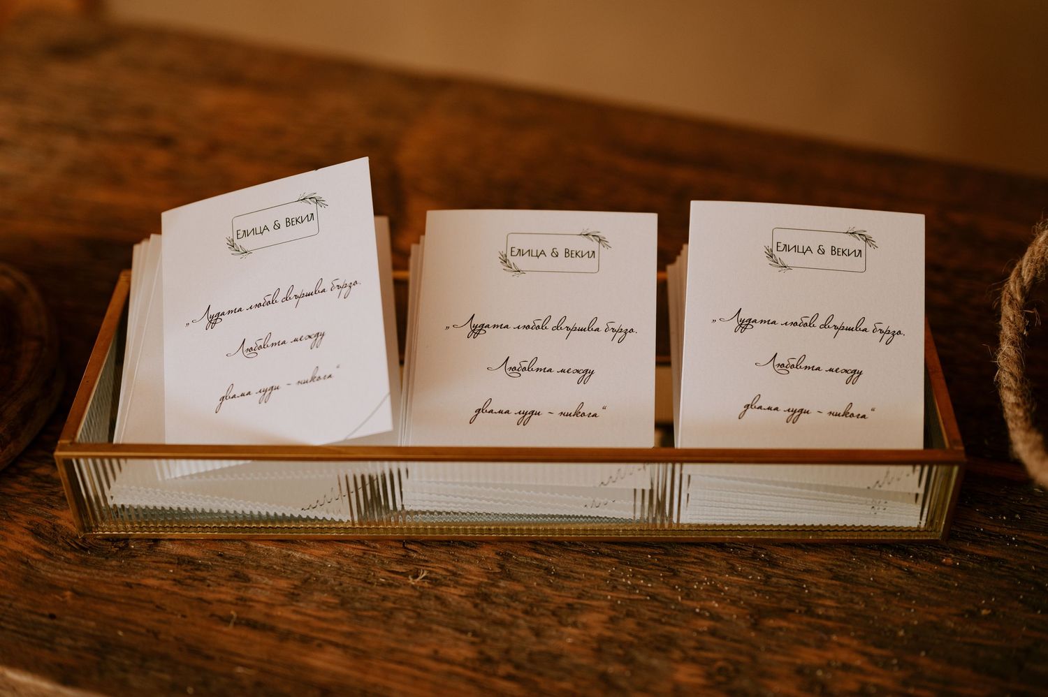 Row of wedding place cards arranged on dark wooden surface.