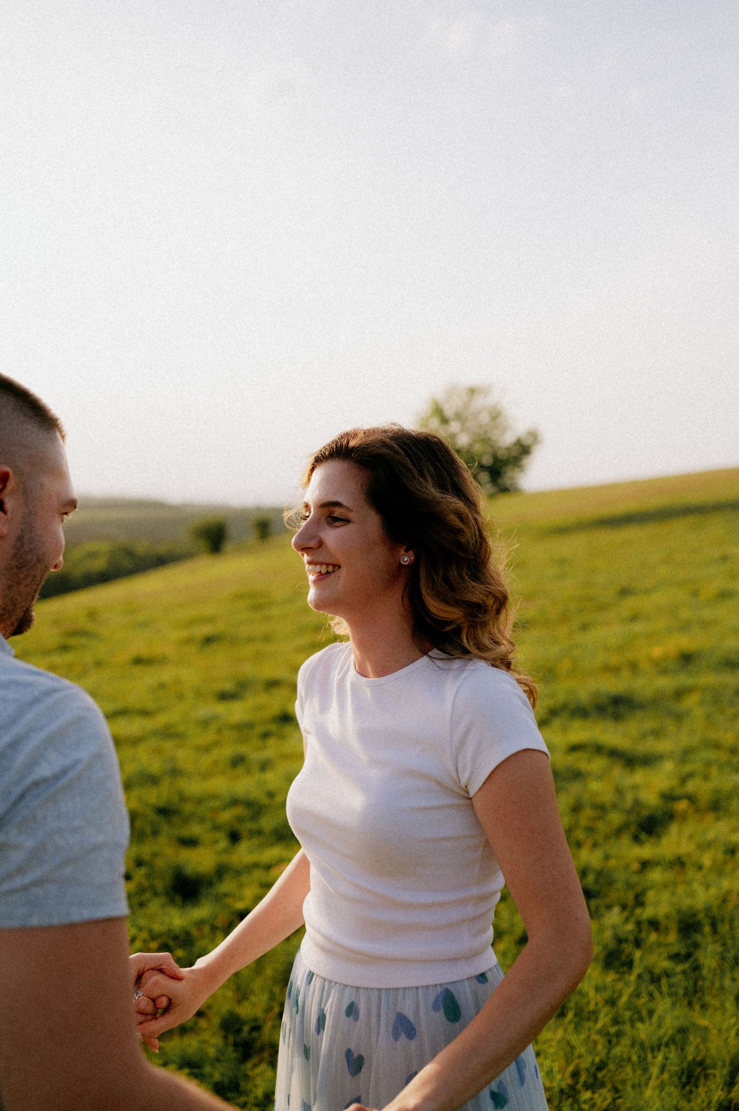 Joyful dance moves captured in a series of photos on a green hillside during golden hour.