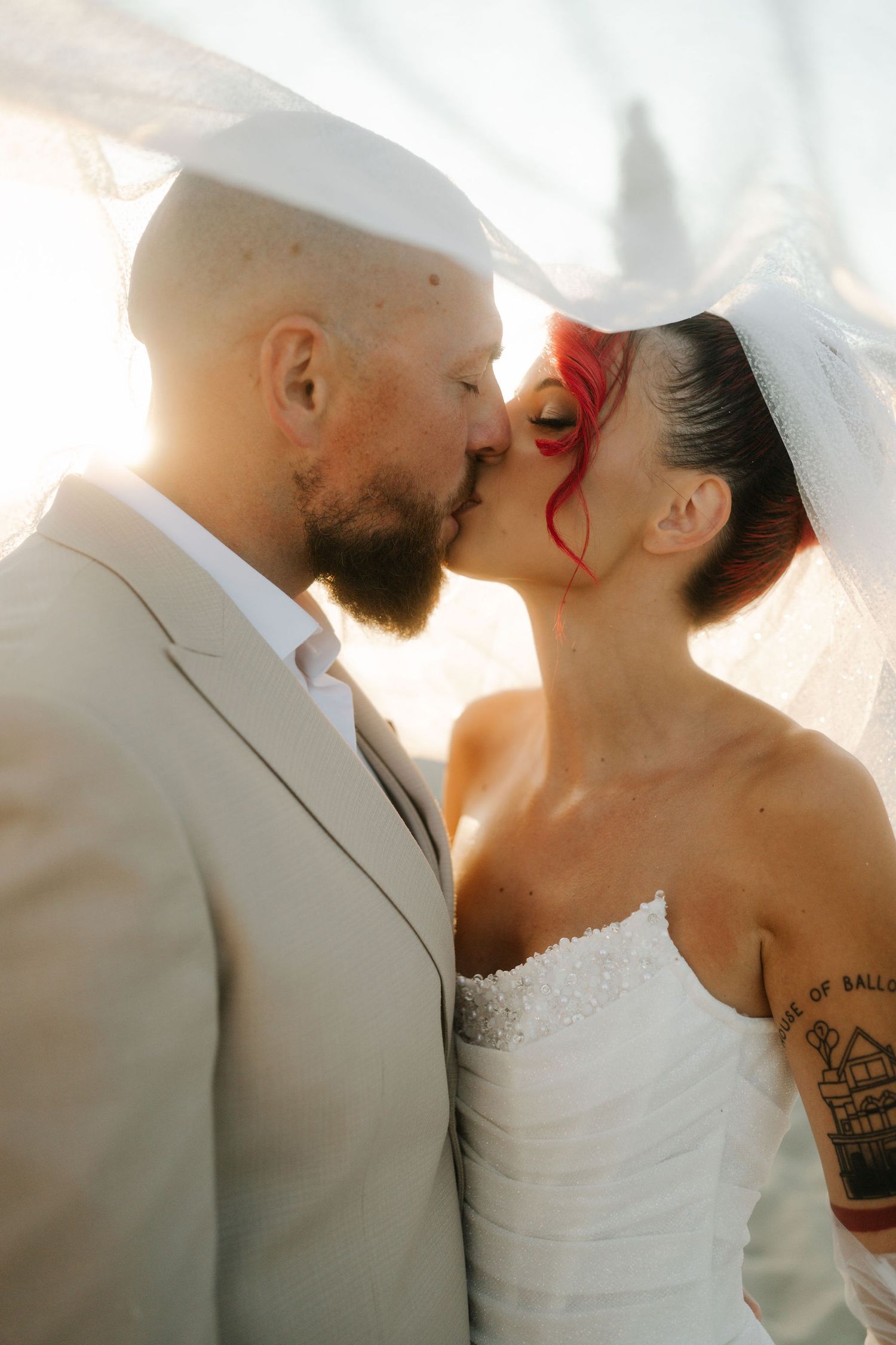 A romantic series of wedding photos showing a couple in white attire kissing at sunset with soft glowing light behind them.