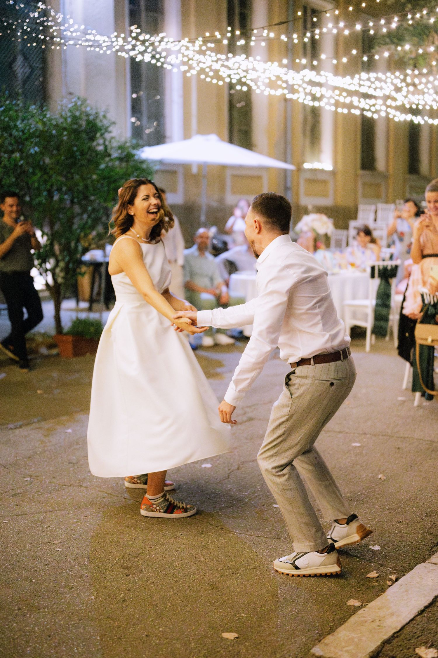 A sequence of five photos showing a couple dancing at a wedding reception under twinkling string lights.