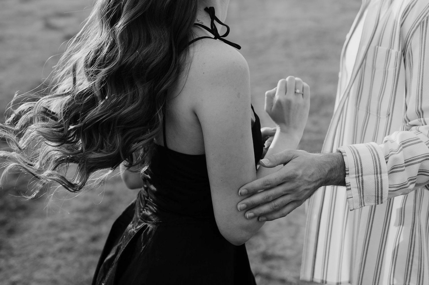 A series of black and white photos showing tender moments between a couple embracing outdoors.