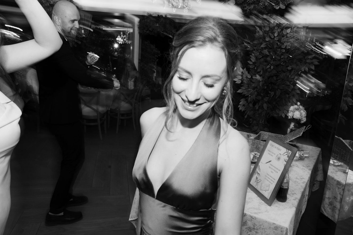 Black and white photo of wedding guests dancing and having fun at a reception party.