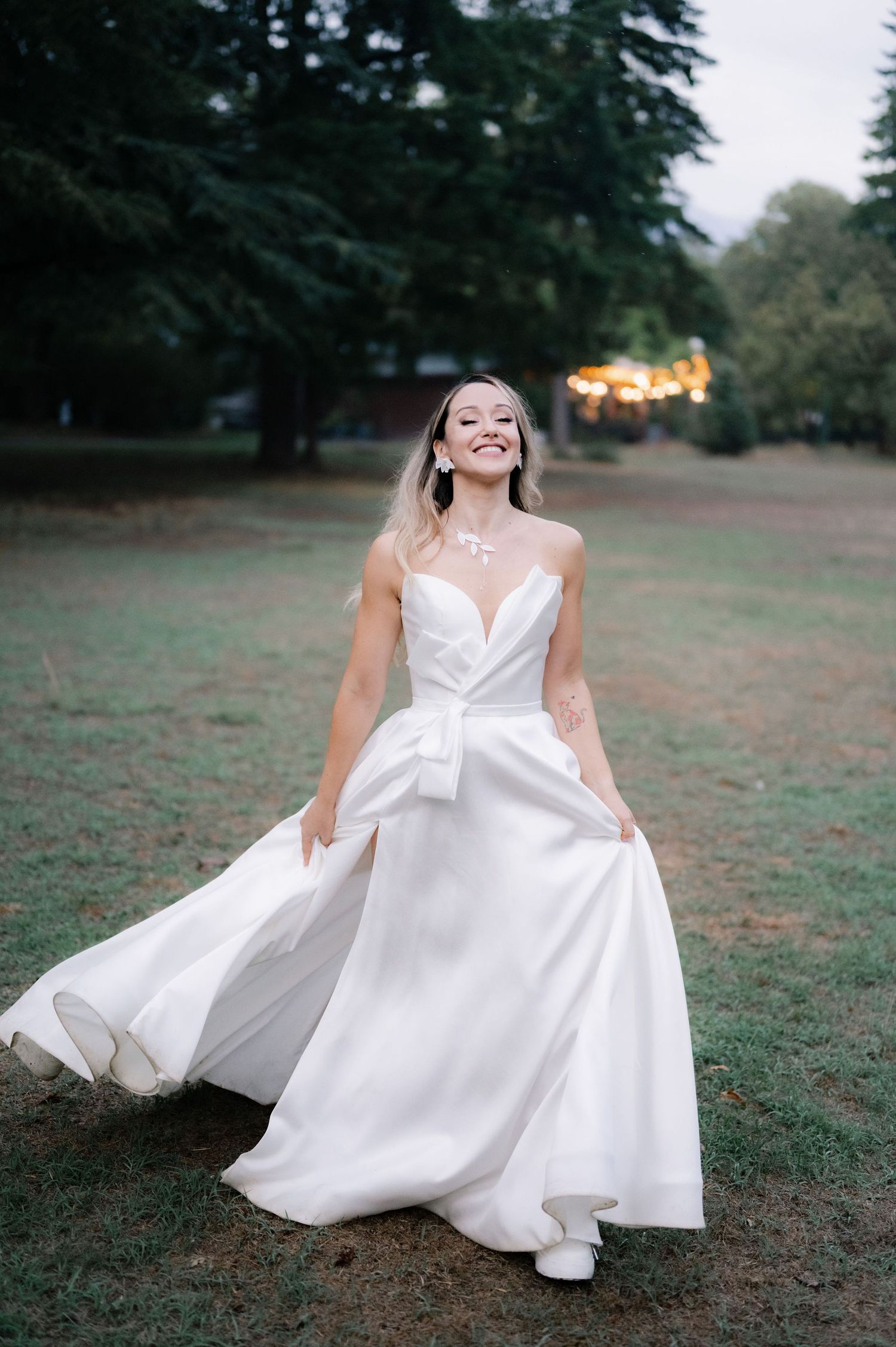 A sequence of photos showing a white wedding dress flowing gracefully across a grassy outdoor setting at sunset.