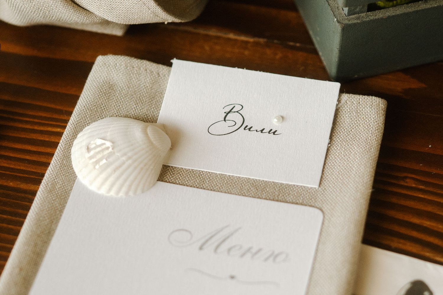 Elegant wedding stationery with calligraphy name cards and envelopes arranged on wooden table.