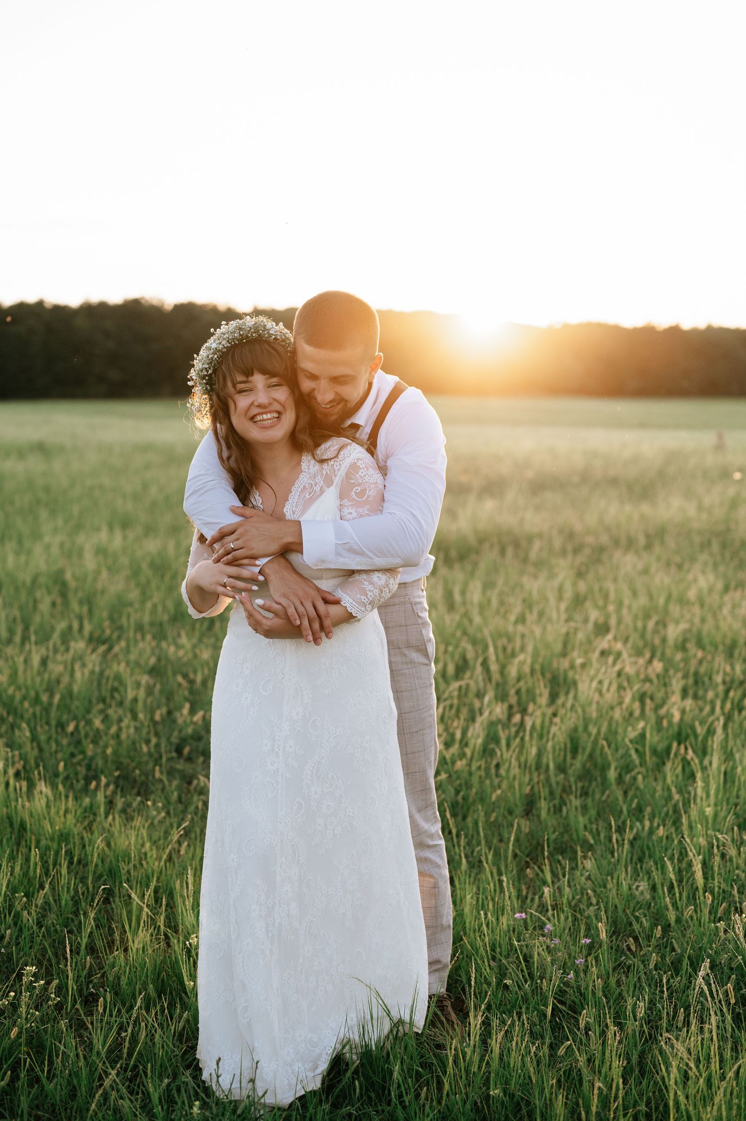 A tender embrace captured during golden hour in a serene meadow setting.