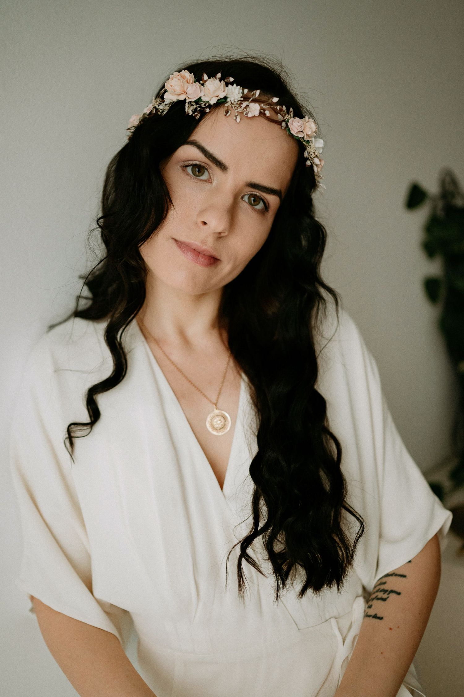 Dreamy bridal portrait featuring white robe and delicate pink floral crown.