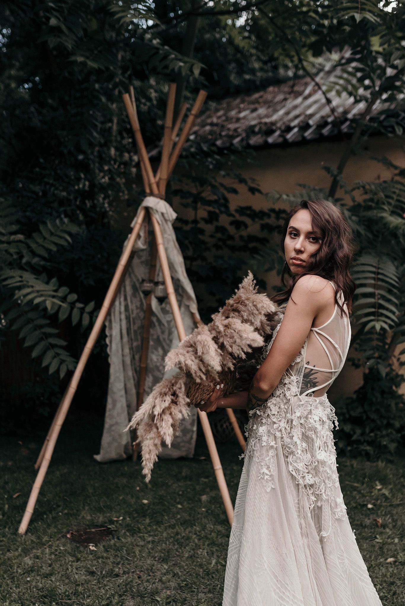 A series of artistic outdoor photos featuring a white dress with dried pampas grass against a dark natural backdrop.