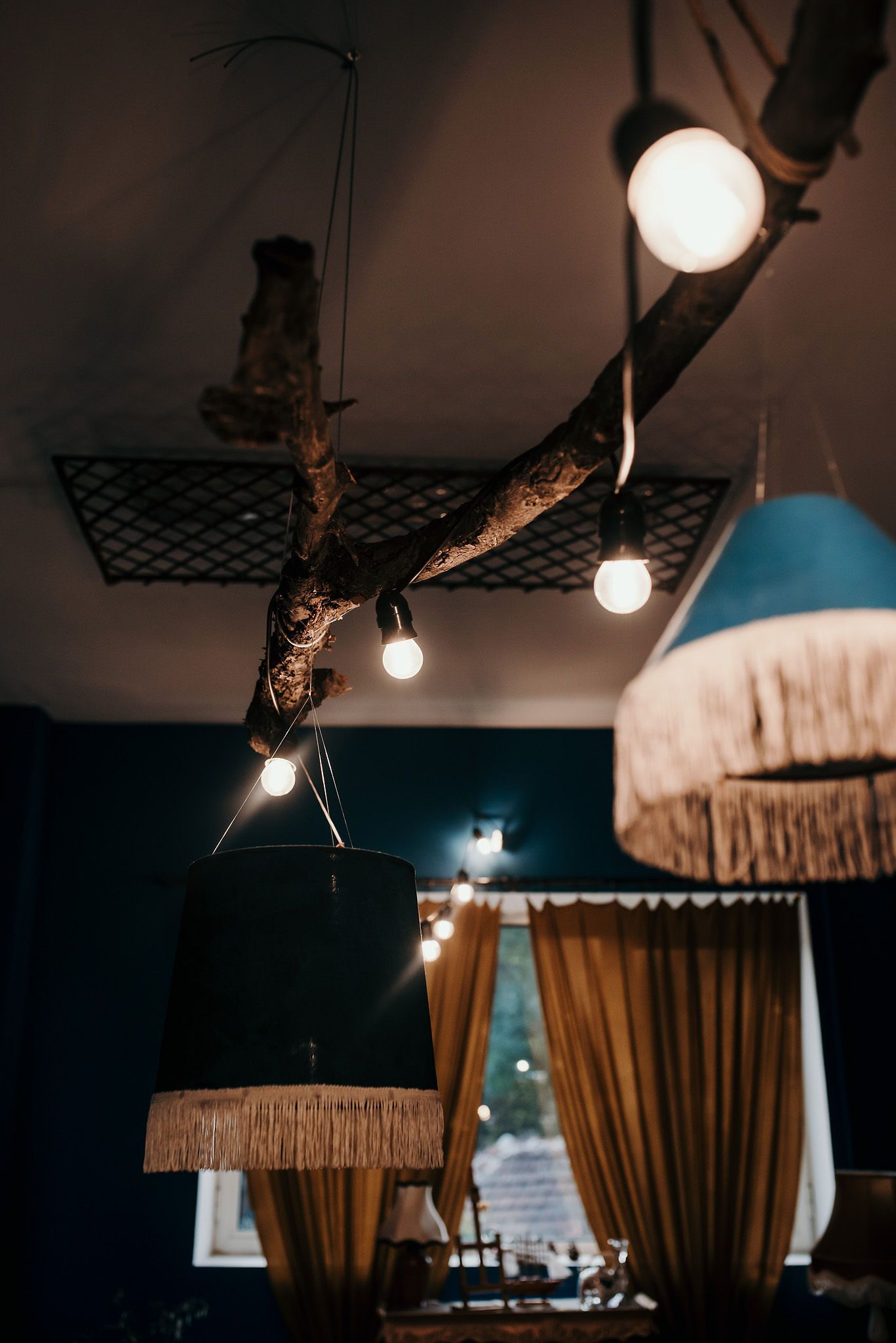 Rustic ceiling light installation with hanging bulbs and vintage-style lampshades.