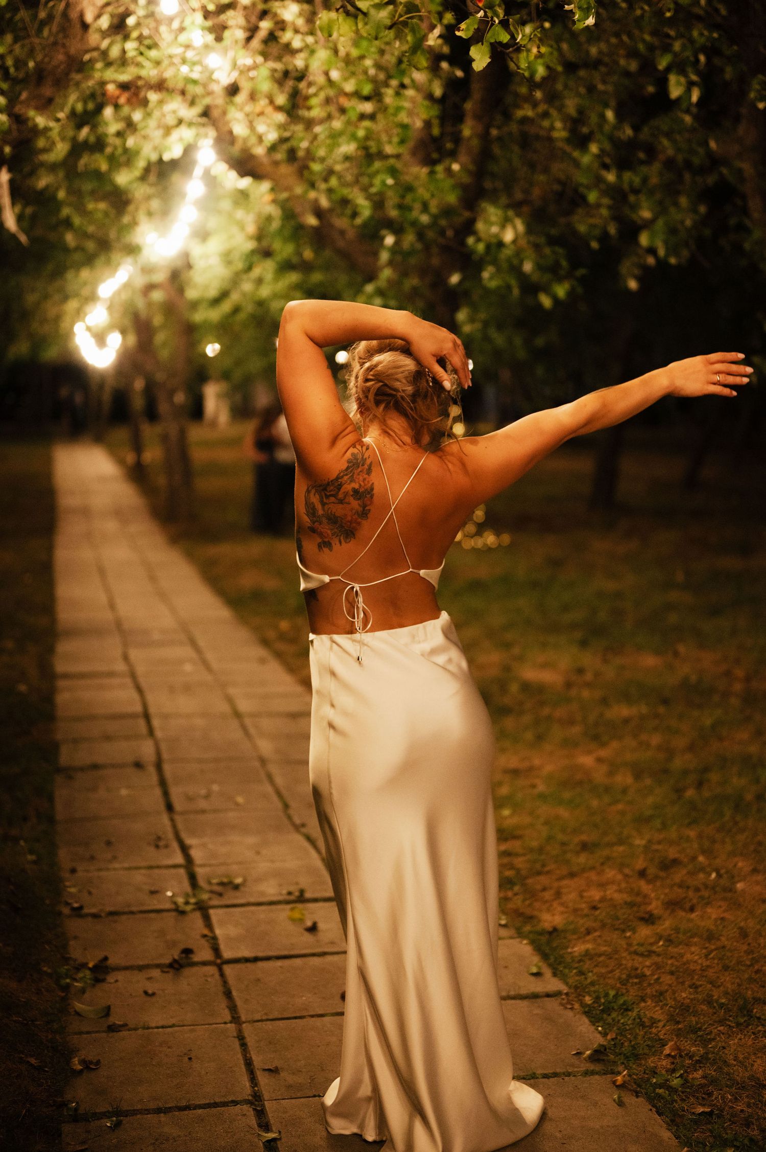 A figure in a flowing white dress dances gracefully through an autumn park at sunset, creating a series of elegant poses.