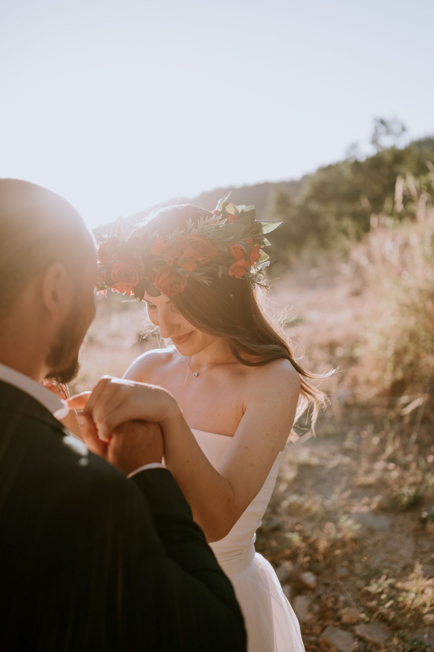 Romantic sunset wedding portrait with couple embracing in golden light.