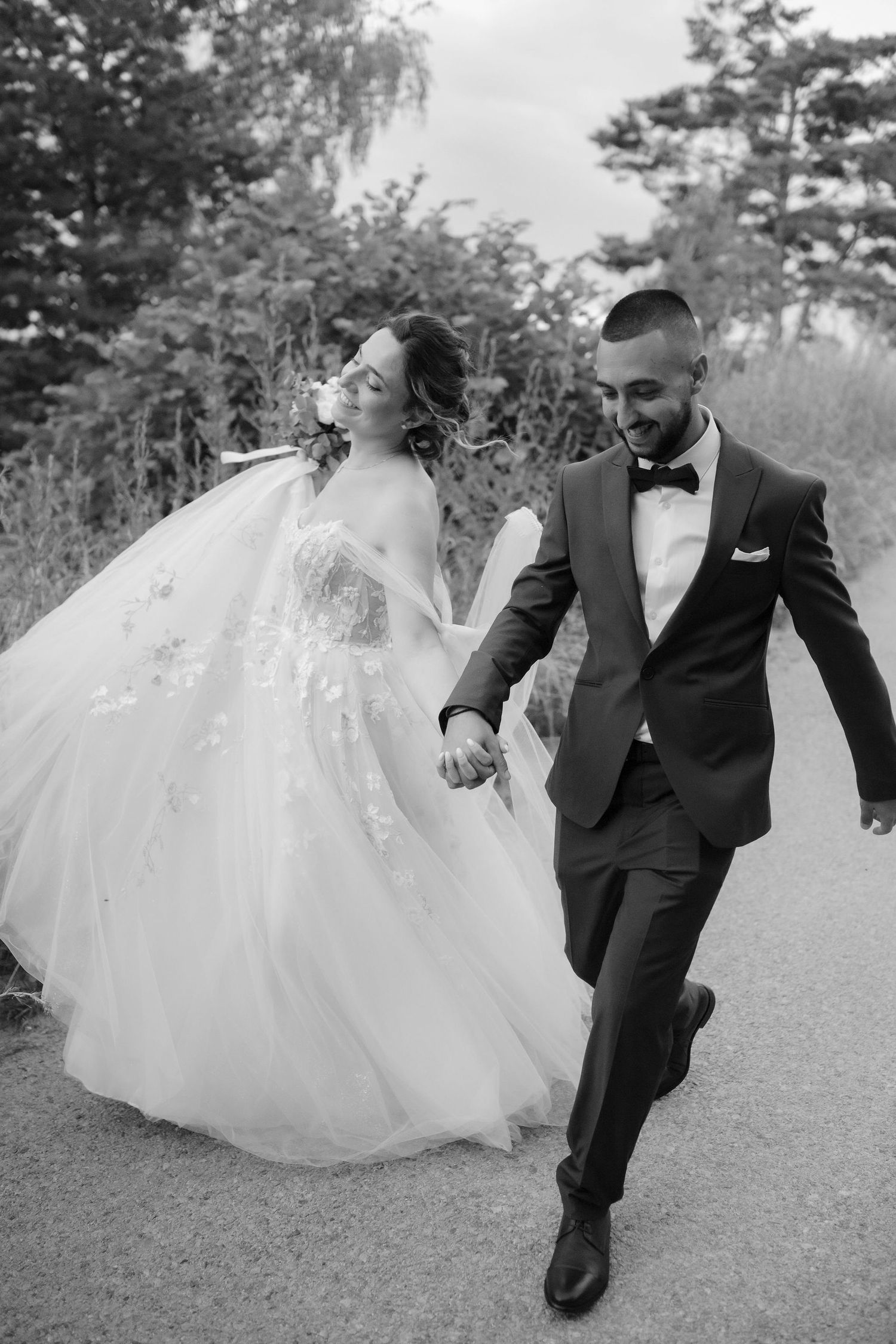 A joyful wedding couple dances and plays together in a series of black and white outdoor portraits.