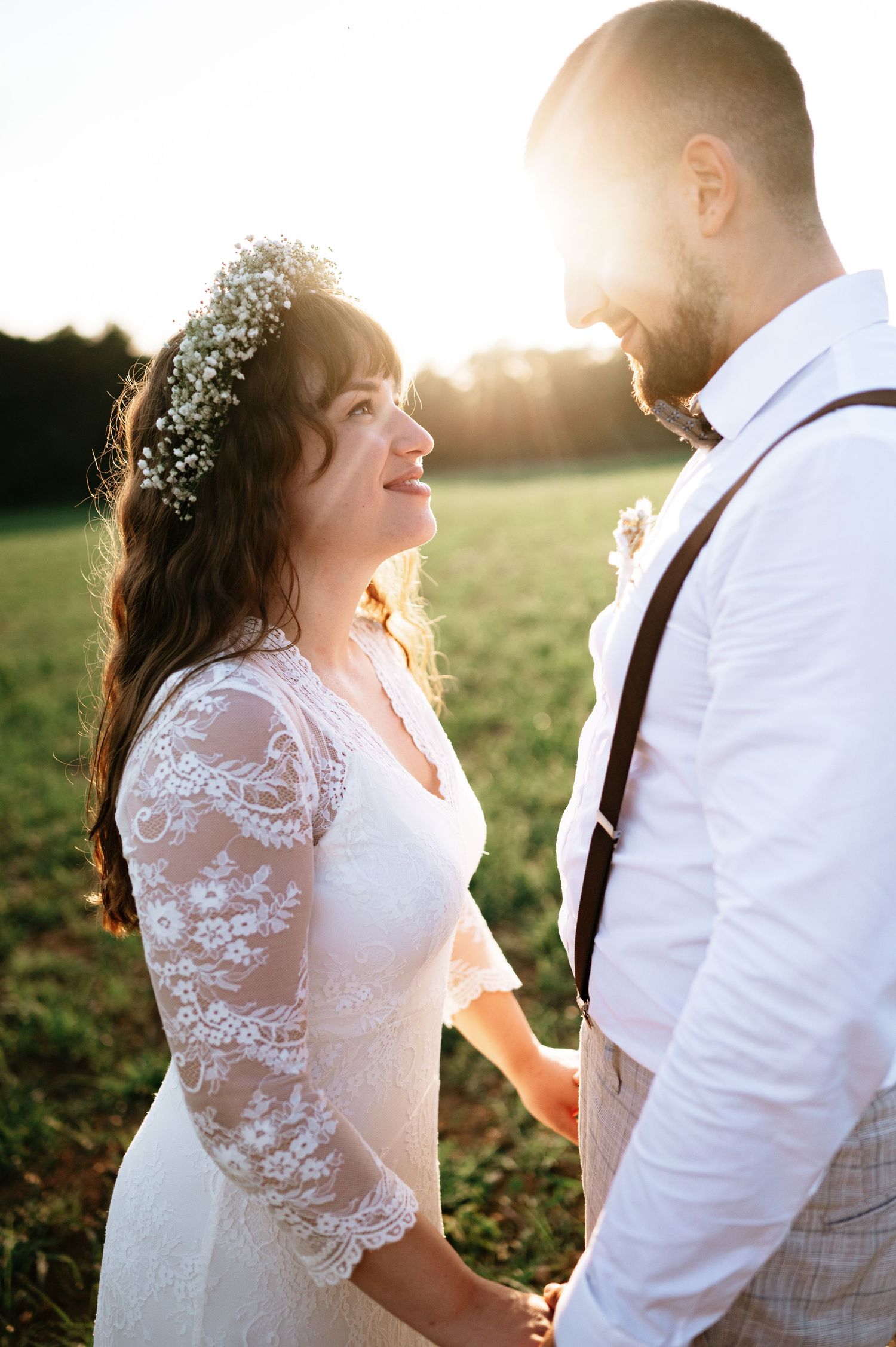 Sun-drenched wedding portraits show couple's intimate moments in rustic outdoor setting.