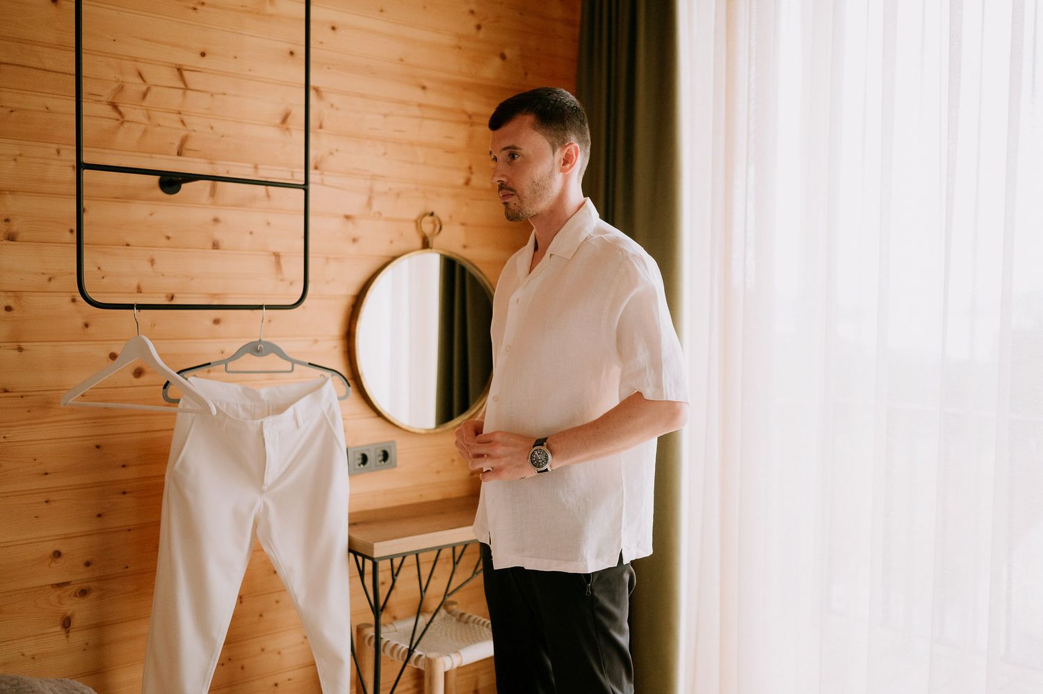 Getting ready scene in rustic wooden cabin with white clothing.